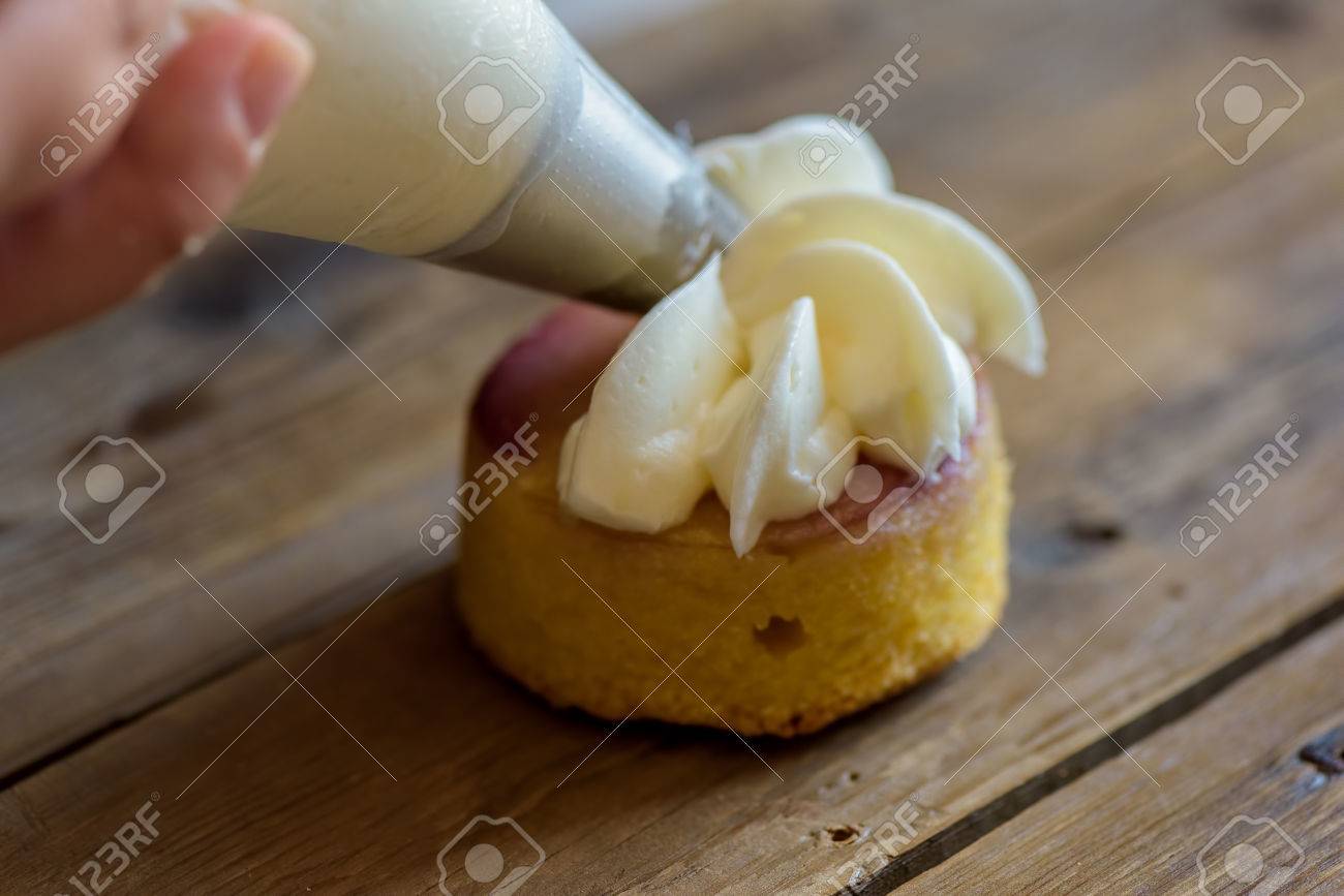 Decorer Un Gateau A La Creme A L Aide D Une Poche A Douille Banque D Images Et Photos Libres De Droits Image