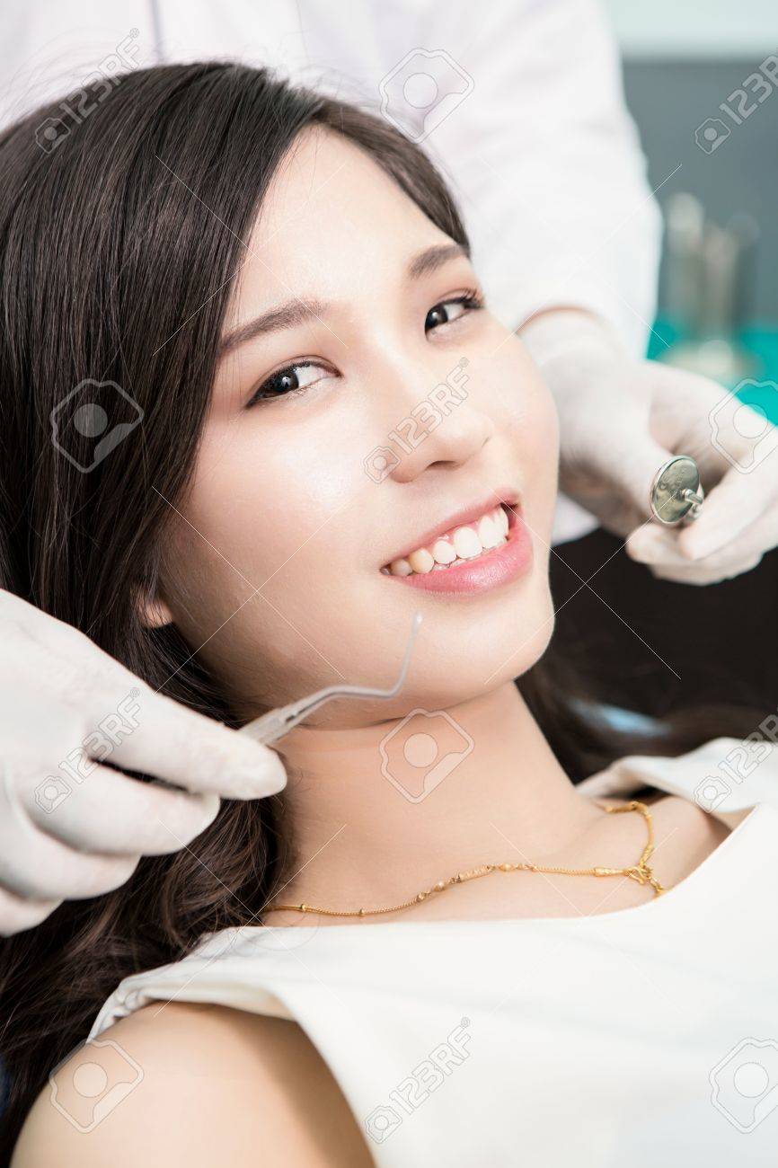 Dentist examining a patient's teeth in the dentist. - 54980480 Dentist examining a patient's teeth in the dentist. - 54980480