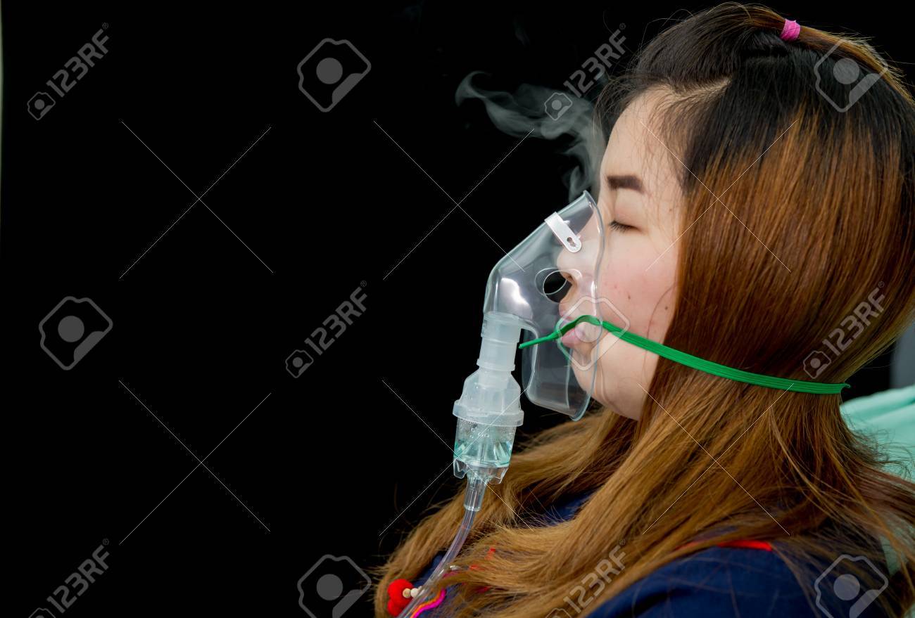 woman holds mask inhaler treatment of asthma. breathing through a steam nebulizer - 63730303 woman holds mask inhaler treatment of asthma. breathing through a steam nebulizer - 63730303