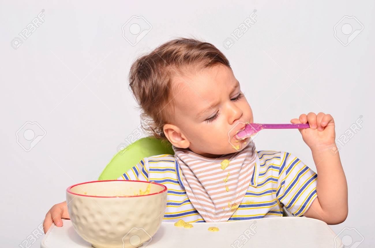 赤ちゃんスプーン 汚い汚いと取得を食べる幼児 幼児の朝食としてオートミールを持つ食べ物 の写真素材 画像素材 Image