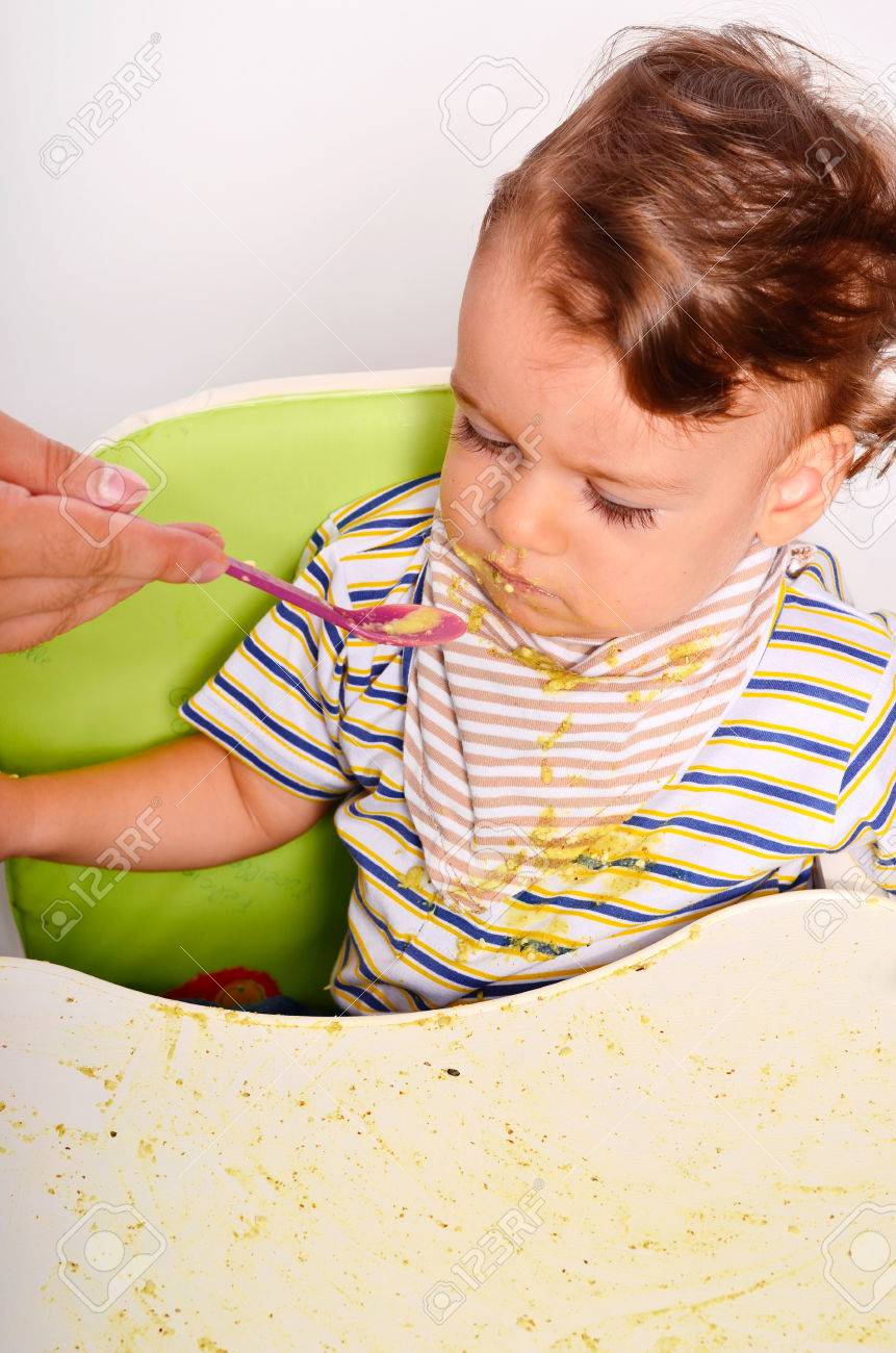 赤ちゃんスプーン 汚い汚いと取得を食べる幼児 幼児の朝食 親の手が彼の子供を餌としてオートミールを持つ食べ物 の写真素材 画像素材 Image