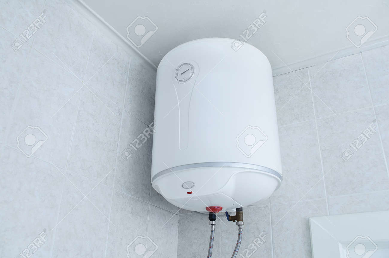 White electric water heater boiler on the wall in the bathroom. - 171076389 White electric water heater boiler on the wall in the bathroom. - 171076389