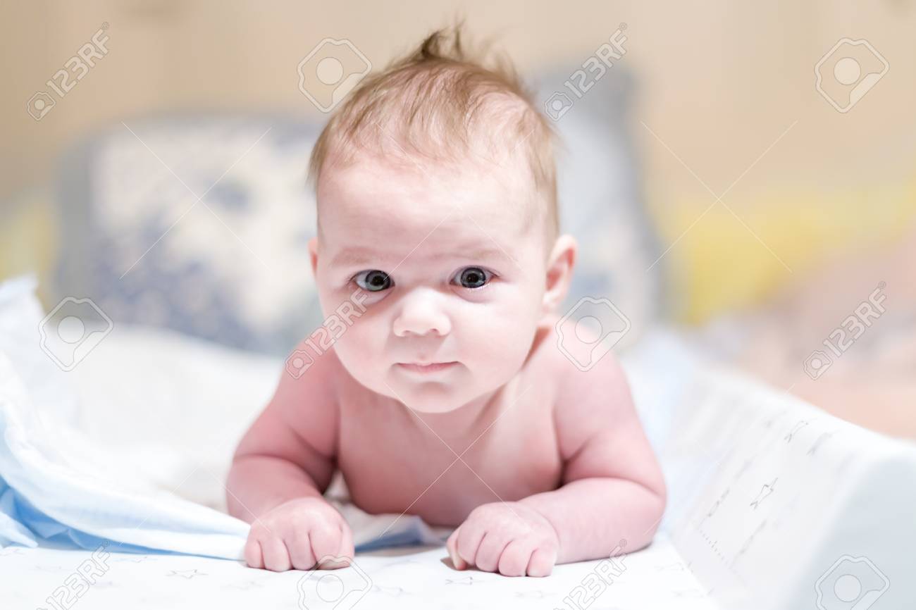 cute baby boy lying on his belly for the first time stock photo