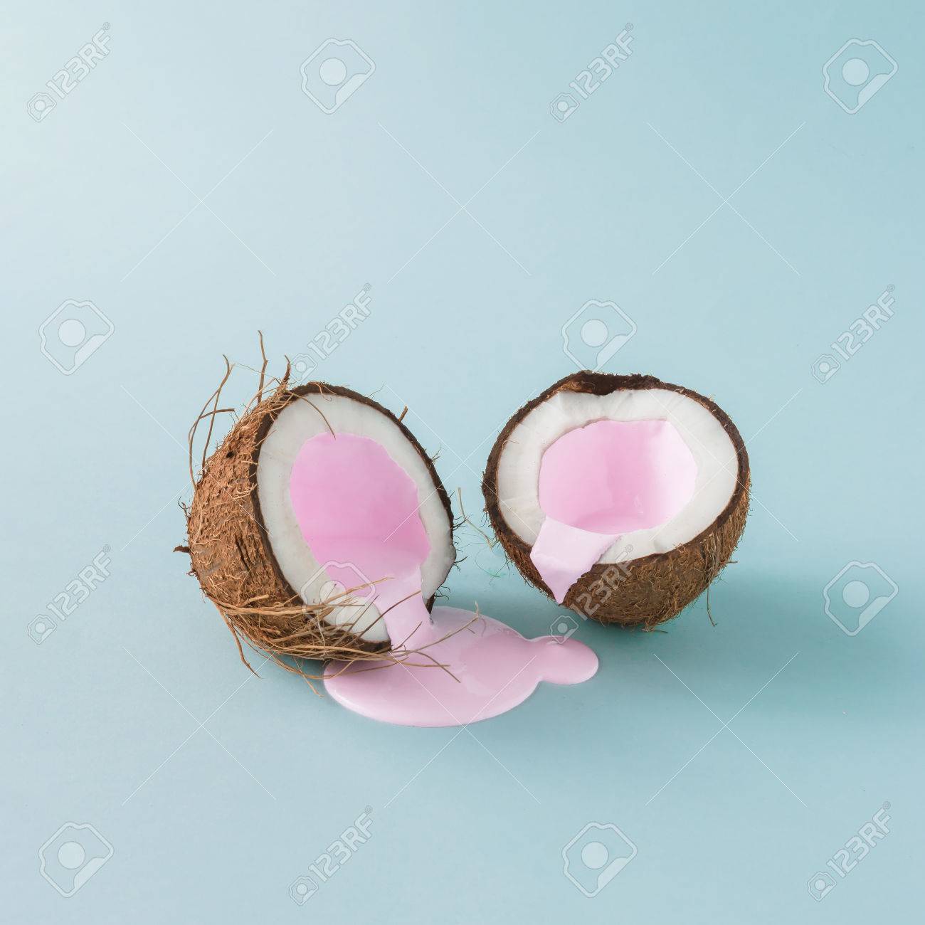 Coconut cracked in half with pink milk pouring. Minimalism. Food creative concept. - 82877726 Coconut cracked in half with pink milk pouring. Minimalism. Food creative concept. - 82877726