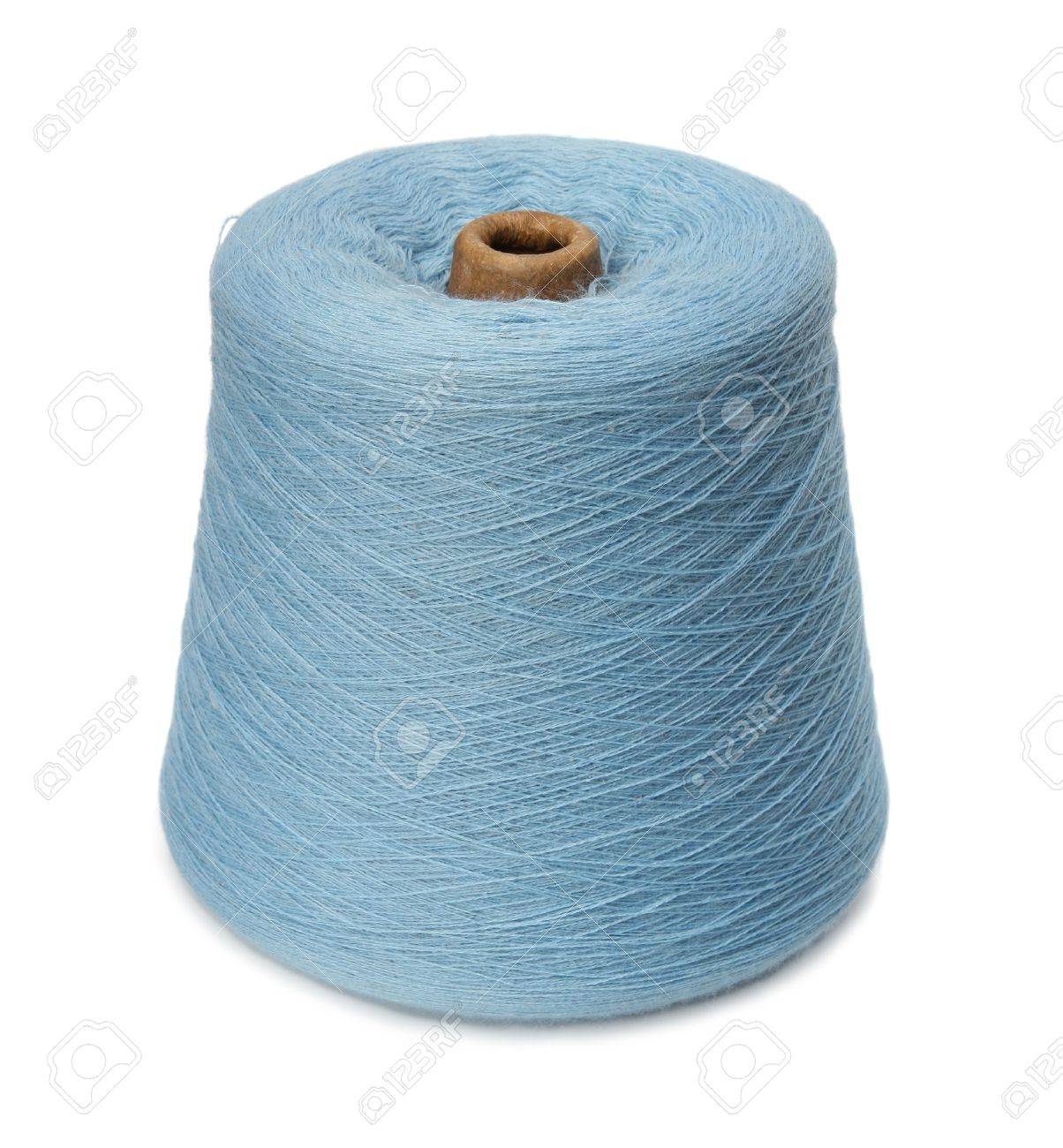the spool of a dark blue yarn on a white background stock photo
