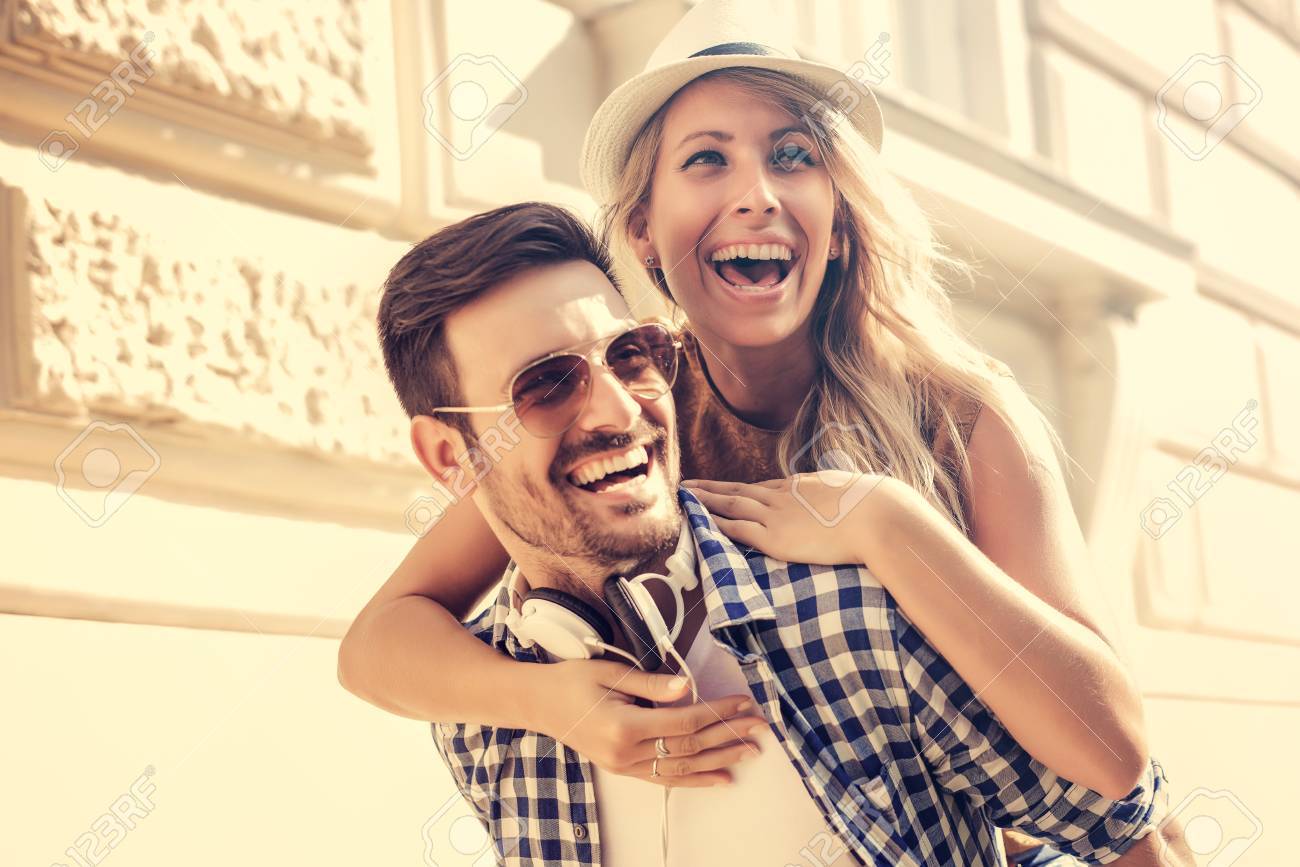 カップルが楽しんでいます 街で女性におんぶを与える男 の写真素材 画像素材 Image