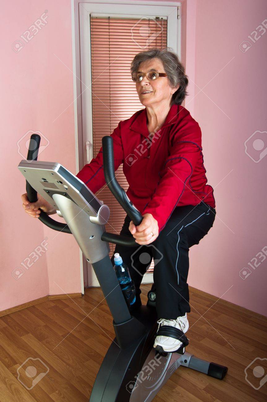 Happy Senior Frau Ausubung Auf Spinning Fahrrad Zu Hause