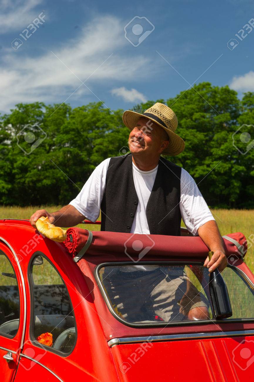 上級フランス語がピクニックを持つ典型的な赤い車の男します の写真素材 画像素材 Image