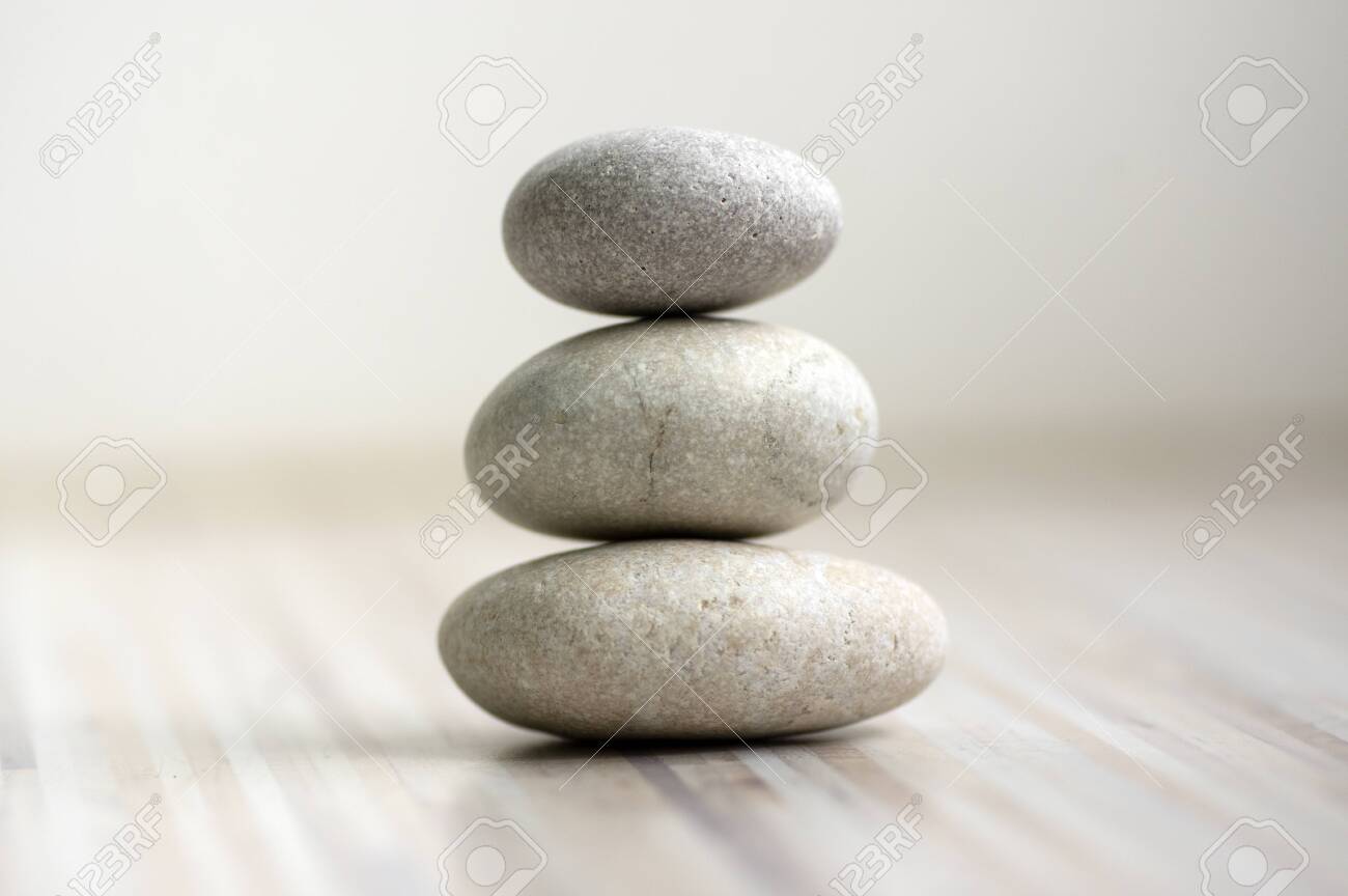 Harmony and balance, cairns, simple poise stones on wooden light white gray background, rock zen sculpture, five white pebbles, single tower, simplicity - 123630459 Harmony and balance, cairns, simple poise stones on wooden light white gray background, rock zen sculpture, five white pebbles, single tower, simplicity - 123630459