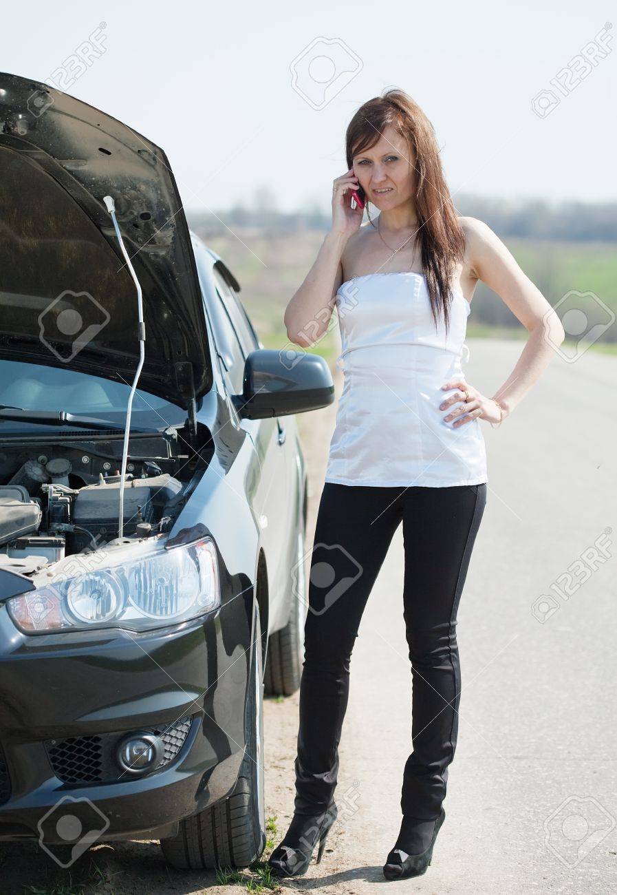 30 代の女性彼女の壊れた車の近くの携帯電話で呼び出す の写真素材 画像素材 Image