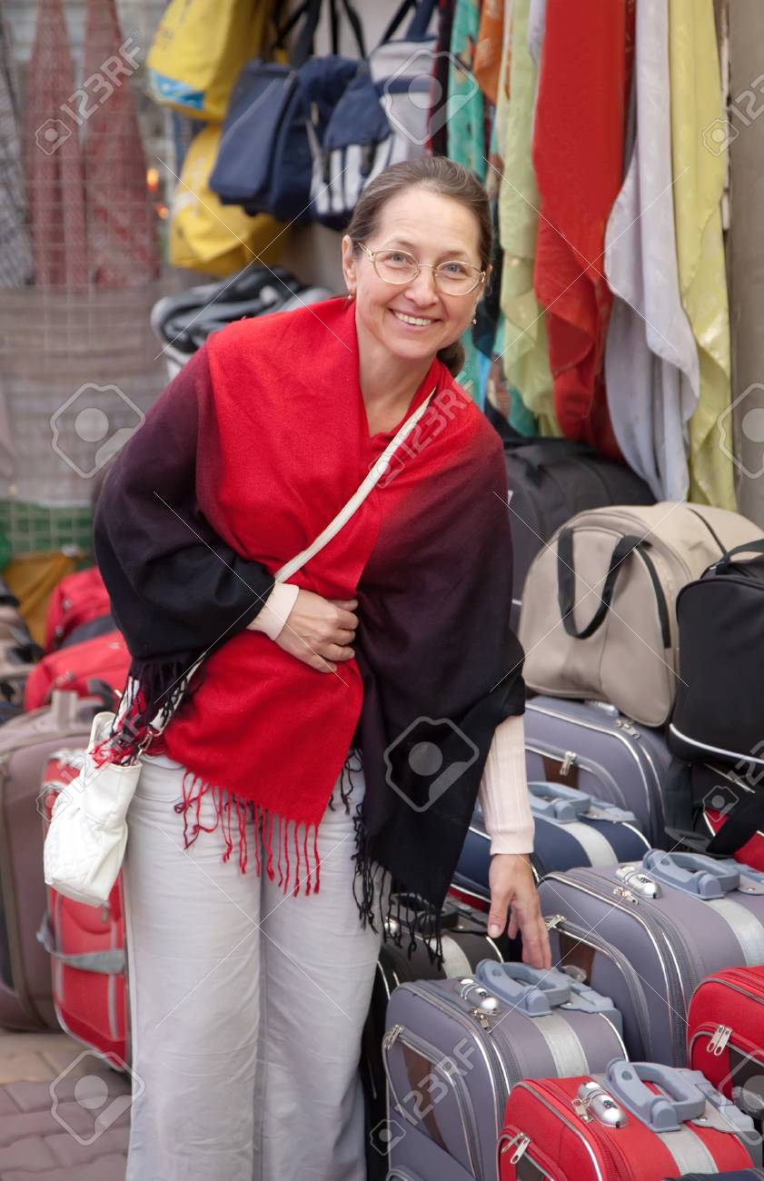 熟女スーツ 熟女店でスーツケースを選ぶの写真素材・画像素材 Image 12436392