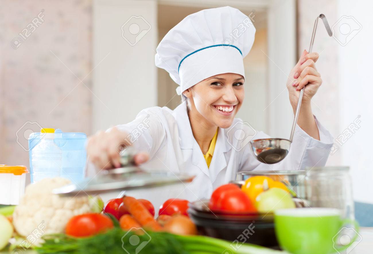 happy professional cook in white workwear works in commercial