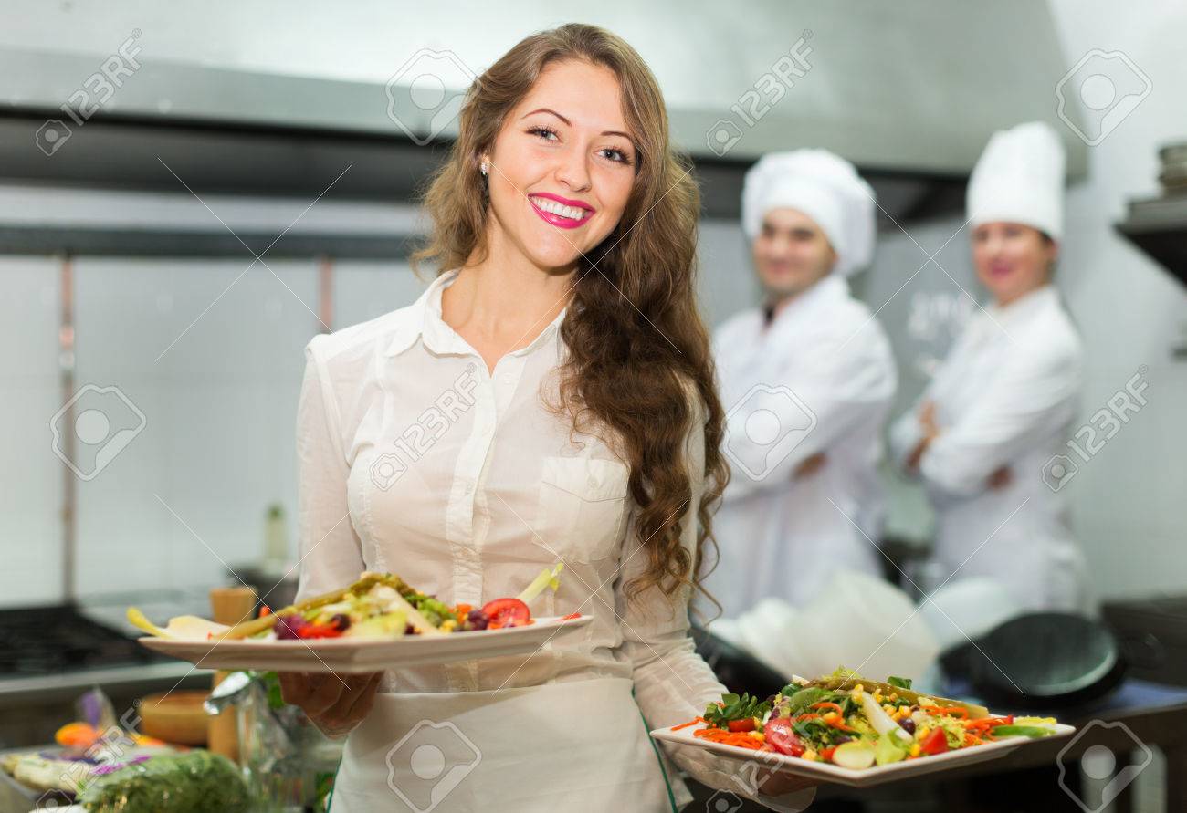 Restaurant Kitchen Chefs team of chefs and young beautiful waiter at the restaurant kitchen Restaurant Kitchen Chefs team of chefs and young beautiful waiter at the restaurant kitchen