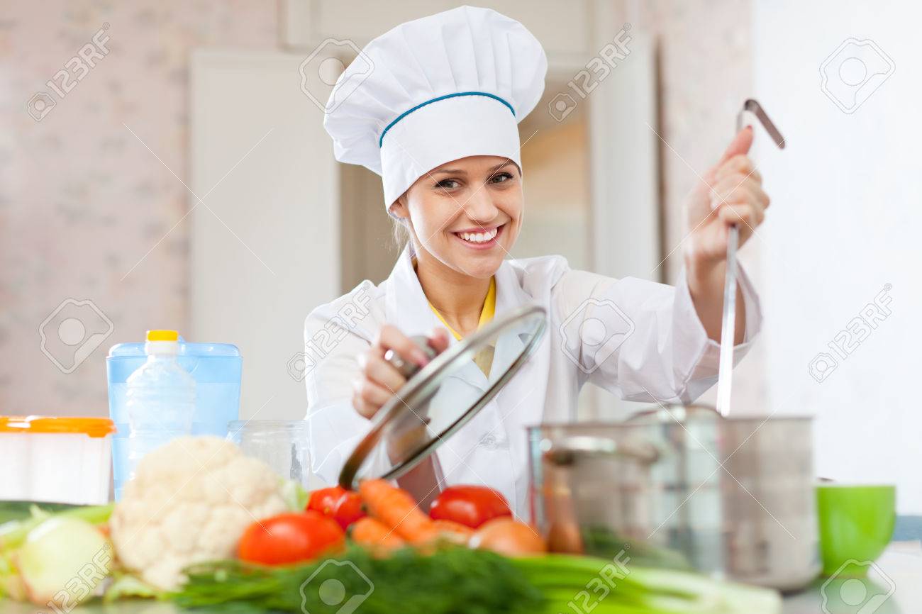 professional cook in white hat works in the kitchen stock photo
