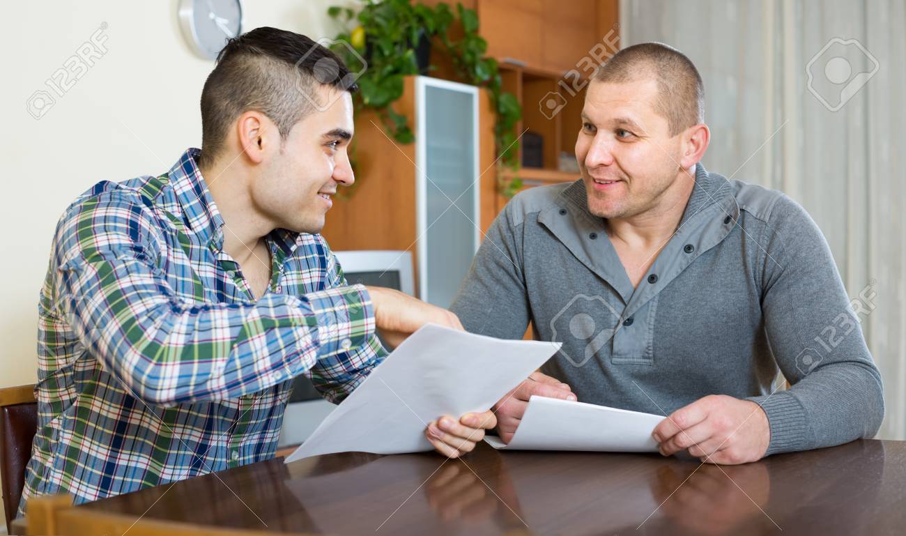 Jeune Agent Male Consultation Client Sur Les Termes Du Contrat A La Table A La Maison