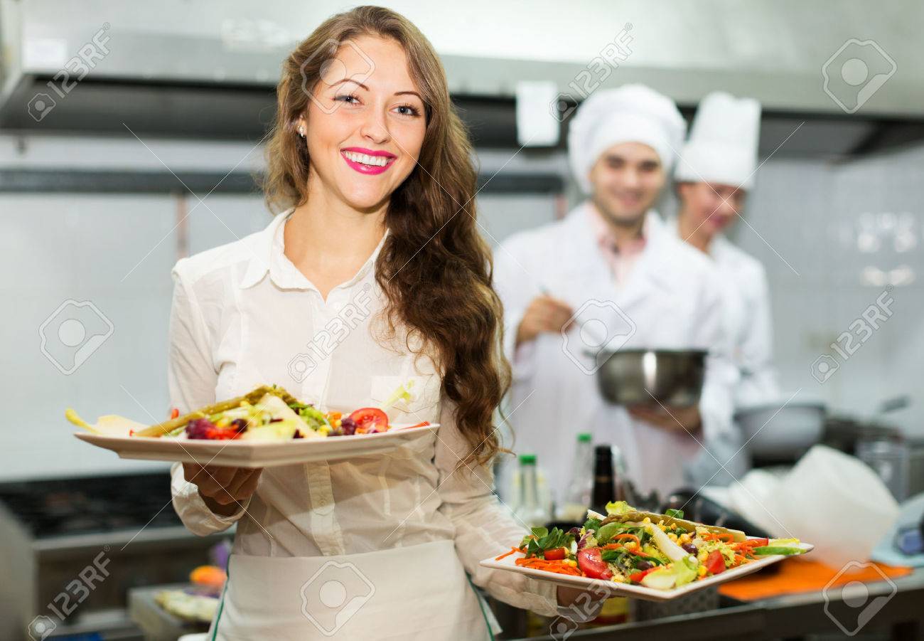 Restaurant Kitchen Chefs team of chefs and young beautiful waiter at restaurant kitchen Restaurant Kitchen Chefs team of chefs and young beautiful waiter at restaurant kitchen