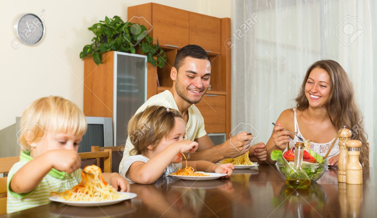 happy family of four people having lunch with pasta at home together - 43730154 happy family of four people having lunch with pasta at home together - 43730154