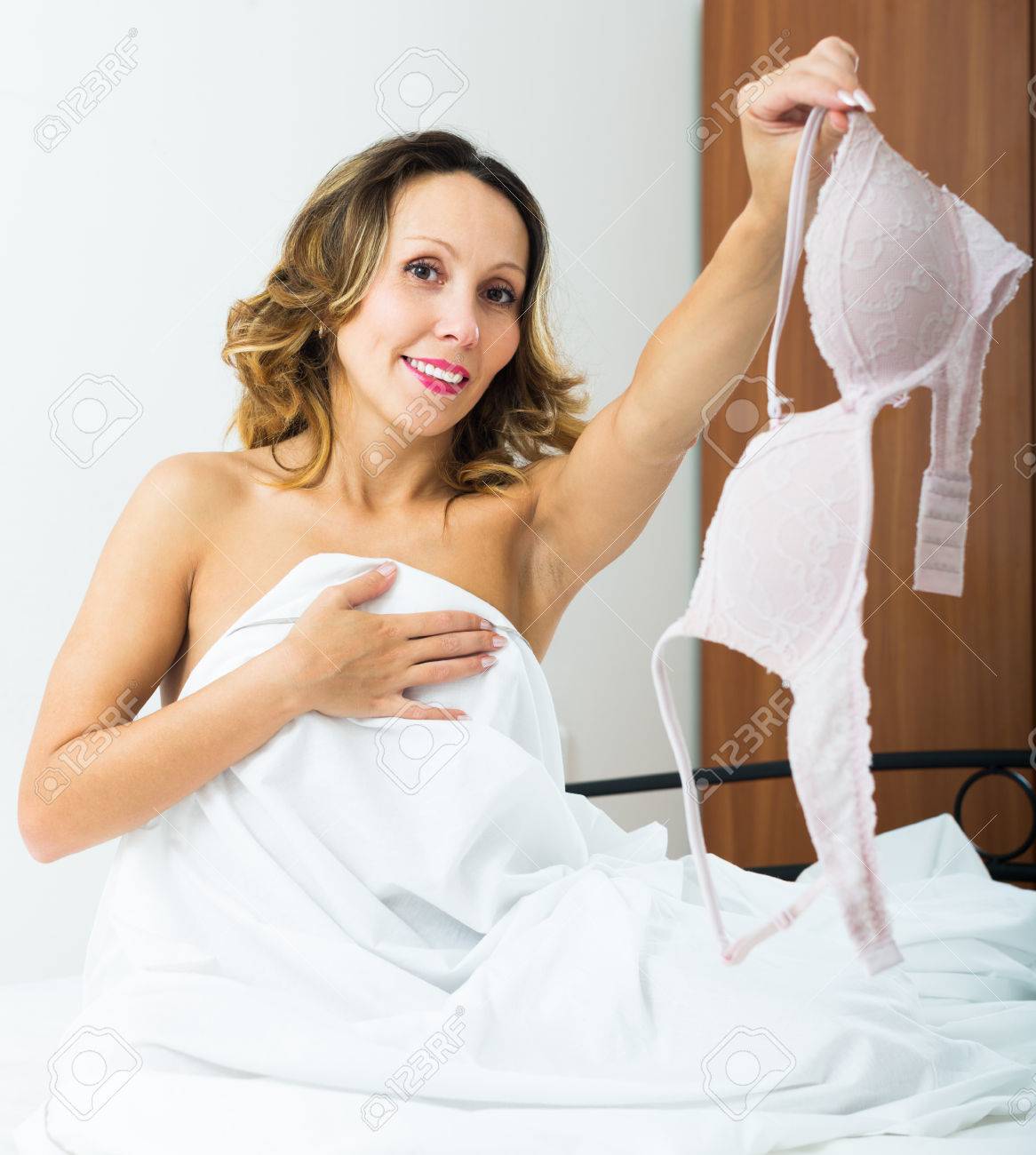 Sexy Middle-aged Woman Sitting And Undressing On The Bed Stock Photo,  Picture and Royalty Free Image. Image 44593025.