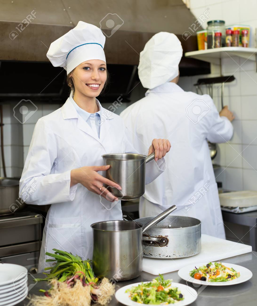 smiling head cooks cooking at professional kitchen in the restaurant chefs and head cooks