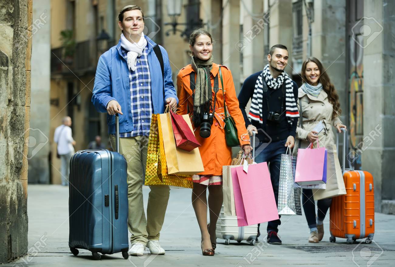 ショッピング バッグや荷物の街で若い観光客の笑みを浮かべて 2 組のカップル の写真素材 画像素材 Image 46979756