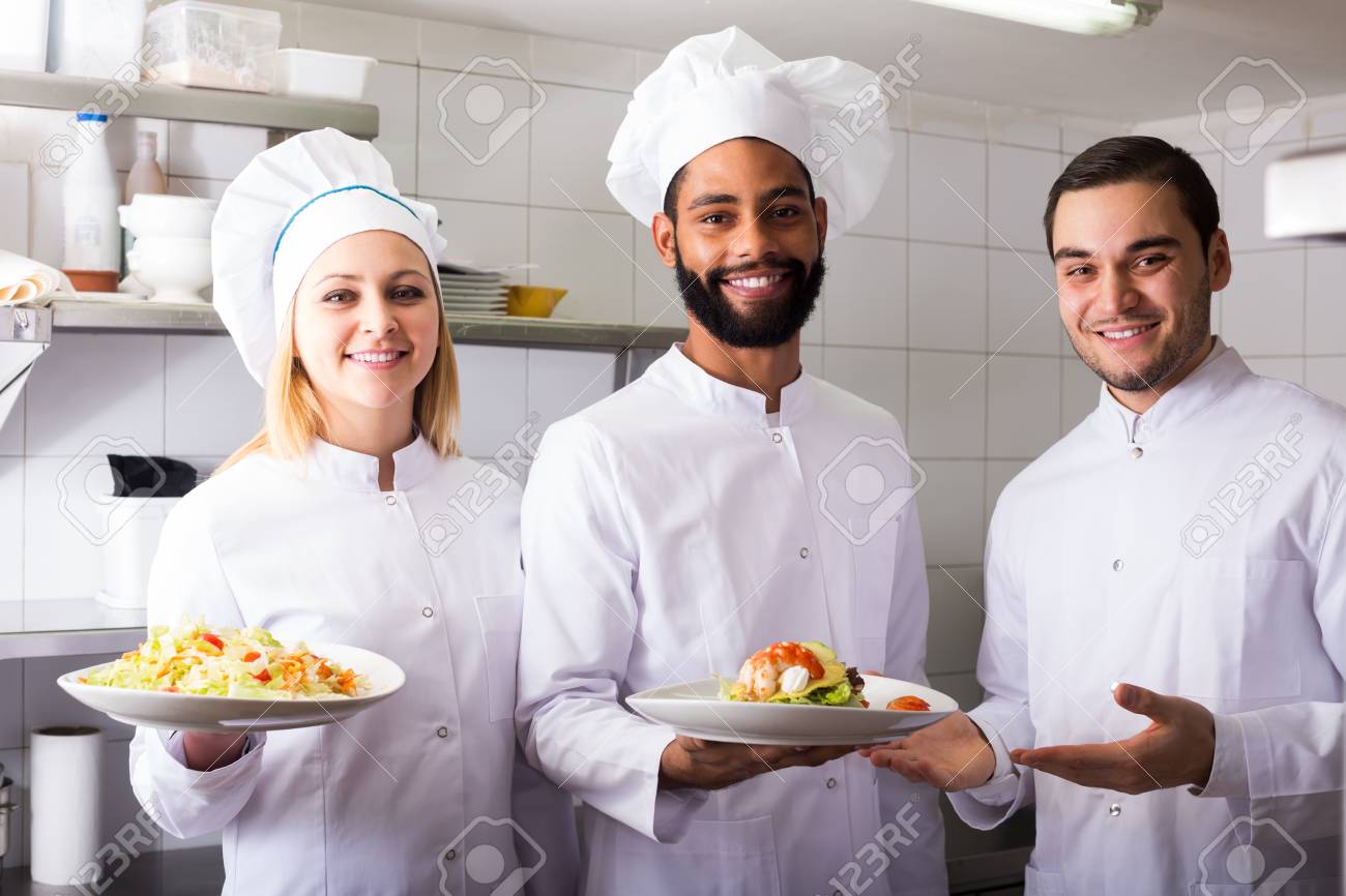 crew of positive spanish professional cooks working at restaurant restaurant working