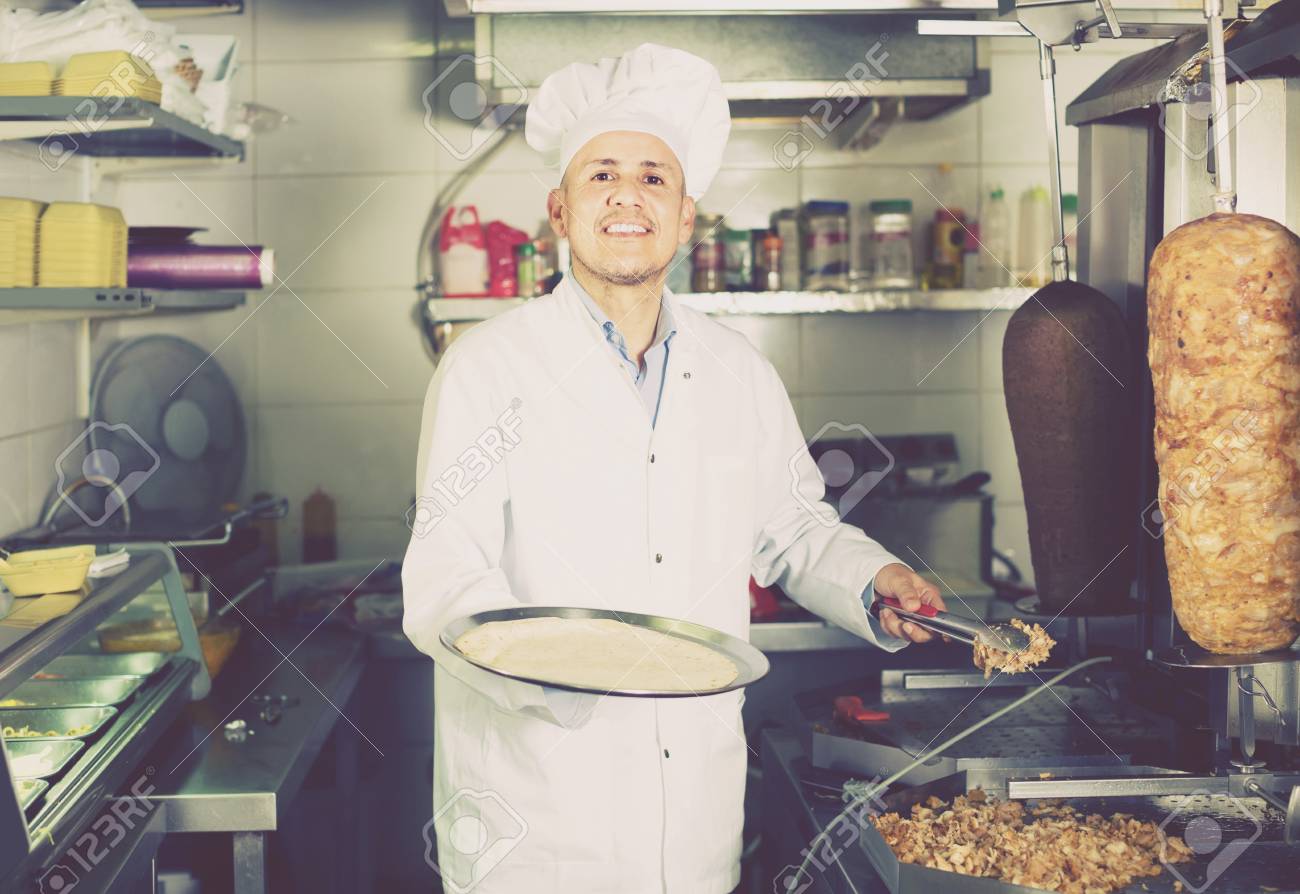 Happy European Mature Man Cook Making Kebab Dish On Kitchen
