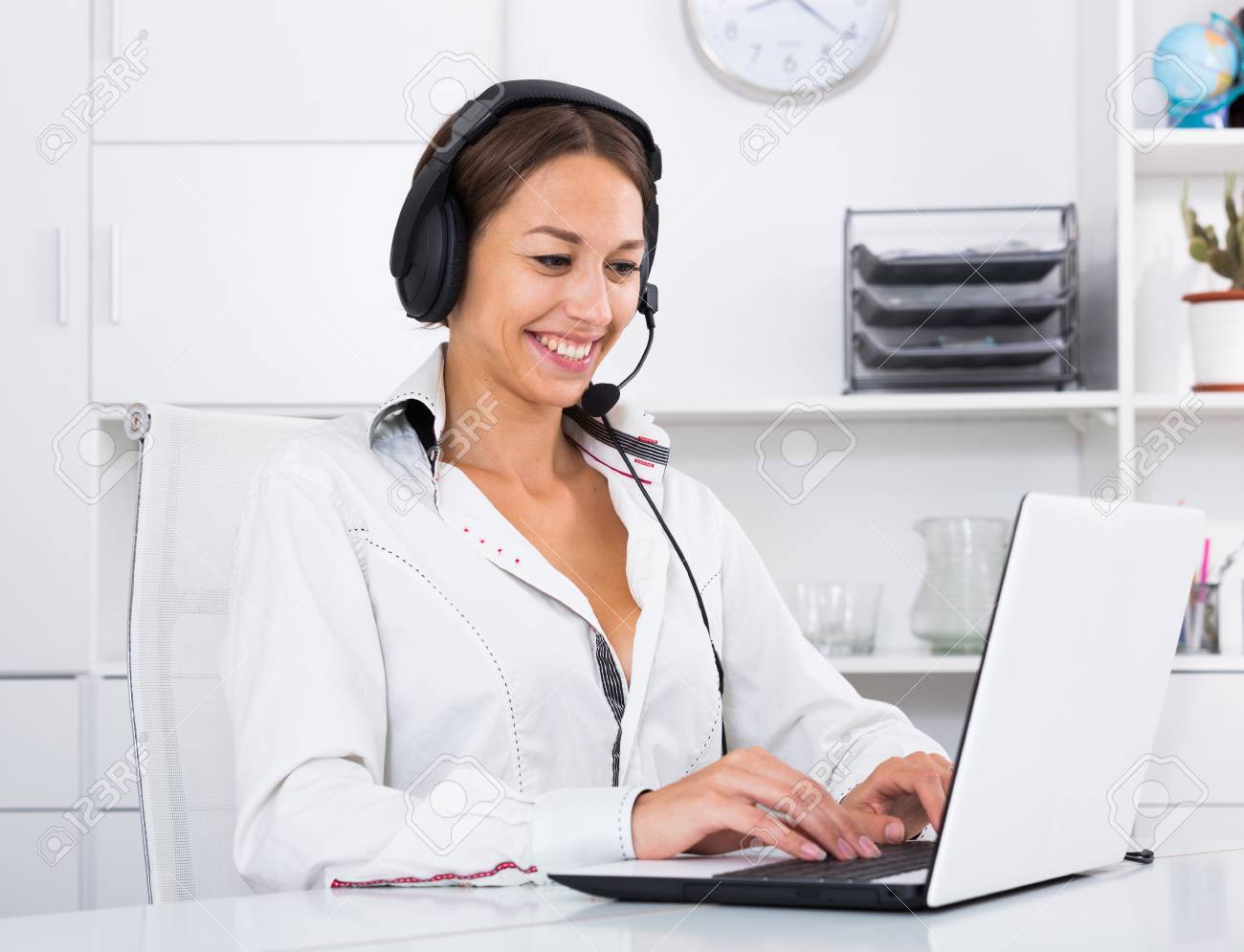 ハンズフリー セットを使用して コール センターで顧客と話しているポジティブ ウーマン の写真素材 画像素材 Image