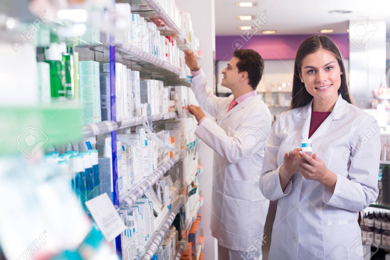 smiling spanish pharmacist and pharmacy technician posing in stock spanish pharmacist