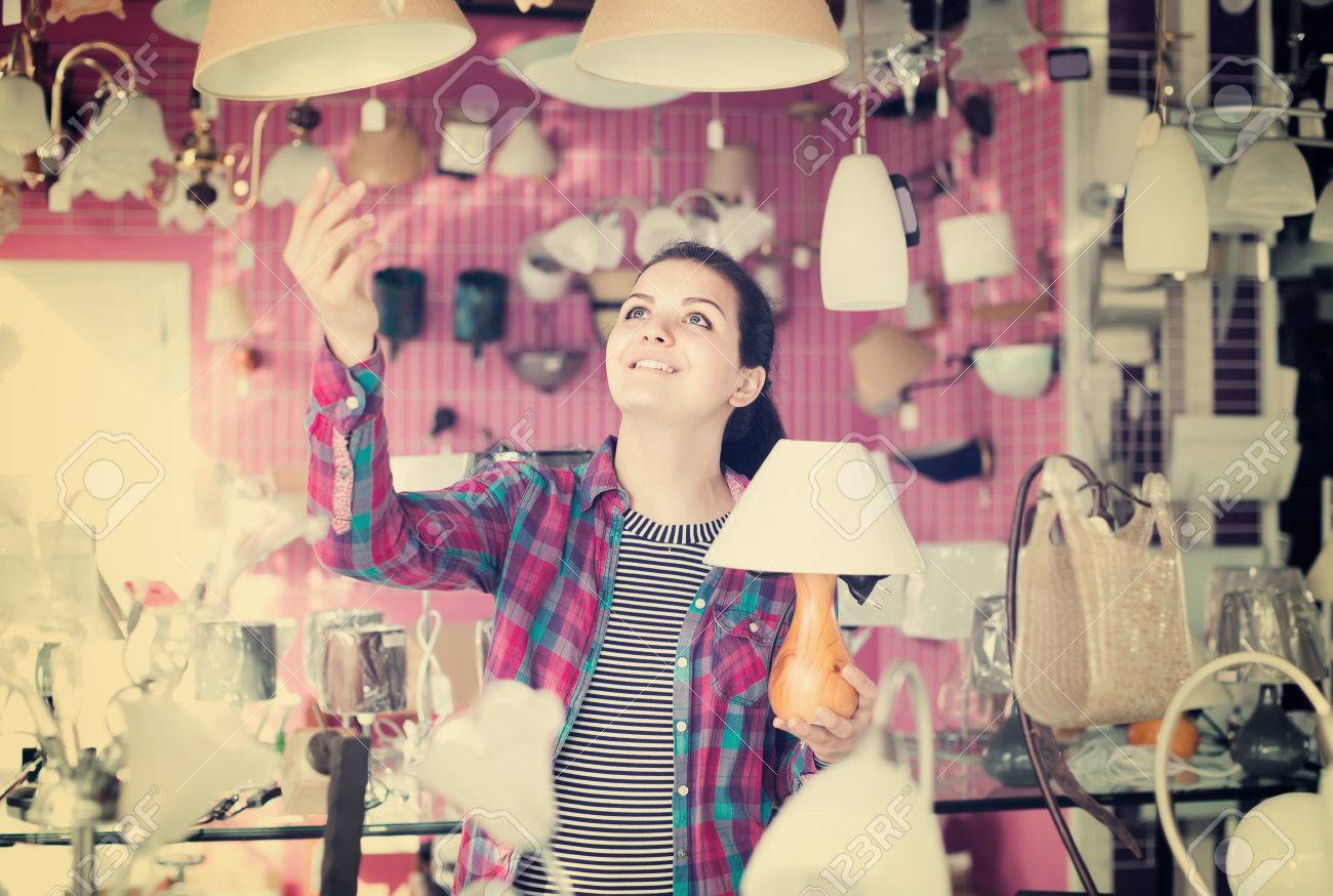 家のインテリアにモダンなガラス シャンデリアを選択するライターの店で若いスペインの女の子 の写真素材 画像素材 Image