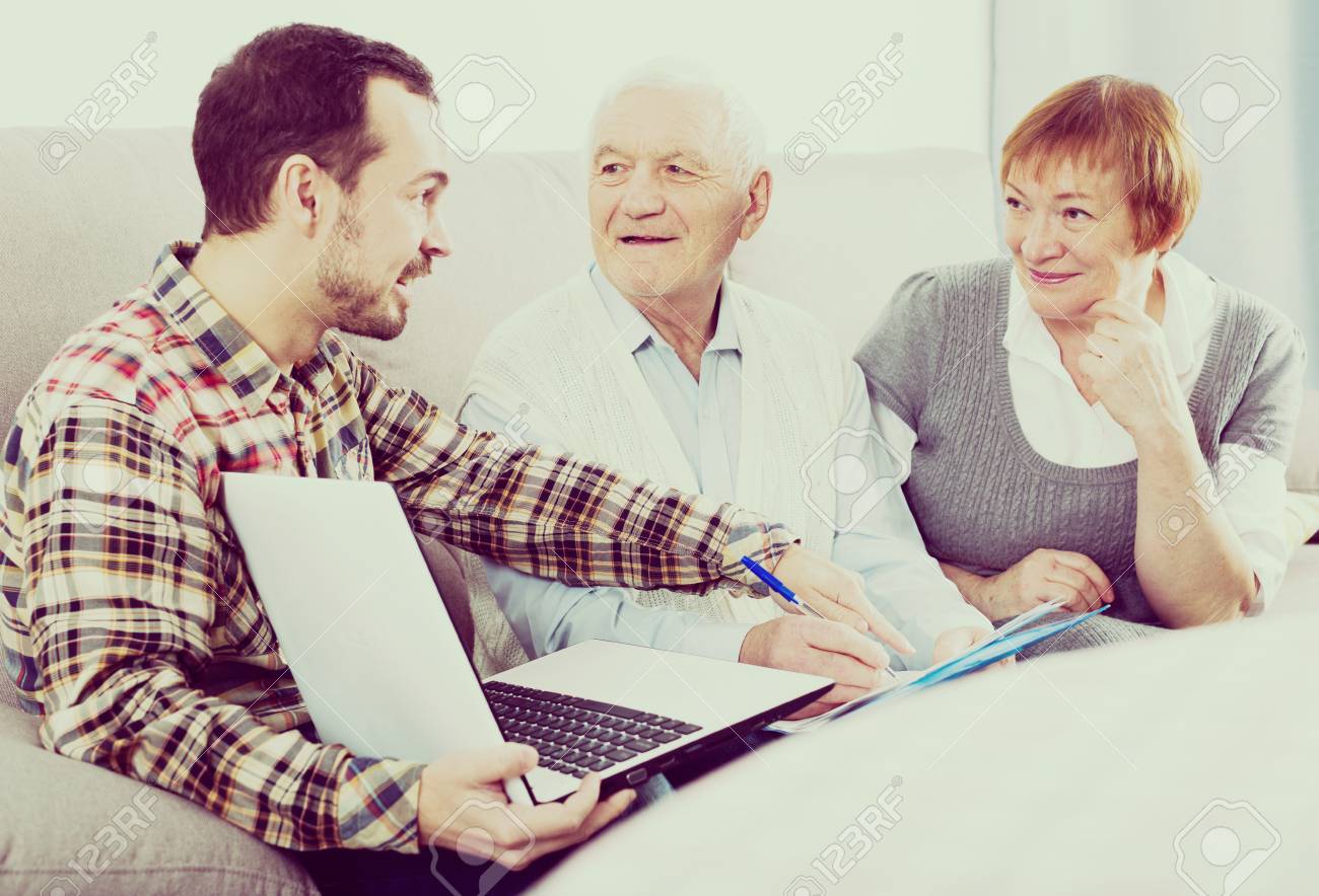 old husband and wife signing agreement papers with social worker