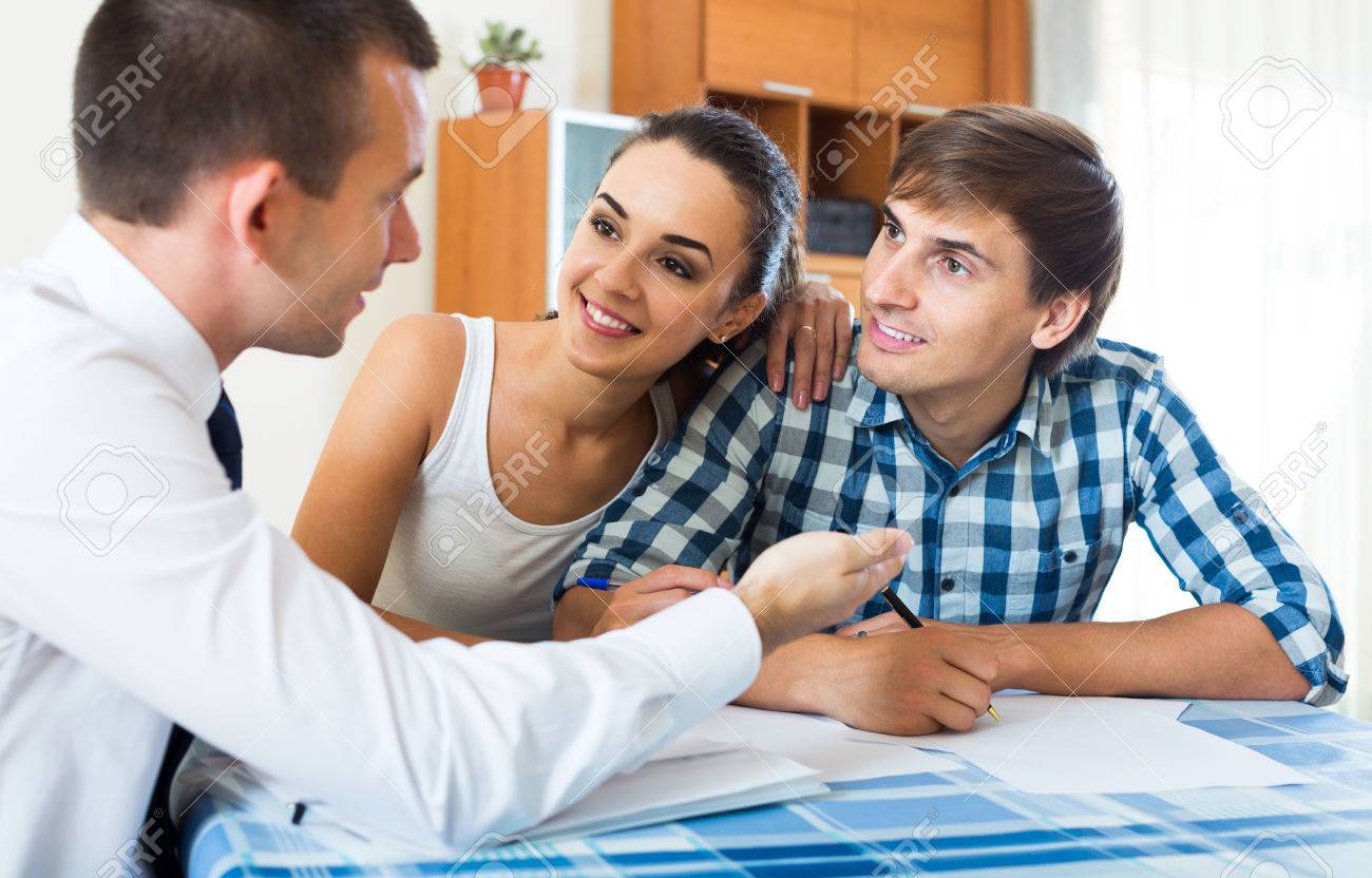 Confiado Vendedor Y Jovenes Felices Esposos Discutir Contrato En