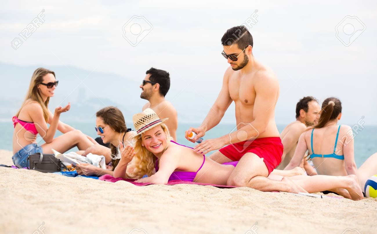 Group Of Healthy People Having A Good Time On A Beach. They Are Smiling,  Talking, Reading And Rubbing Sunblock Cream Into Their Bodies Stock Photo,  Picture and Royalty Free Image. Image 89510226., image size:1300x808