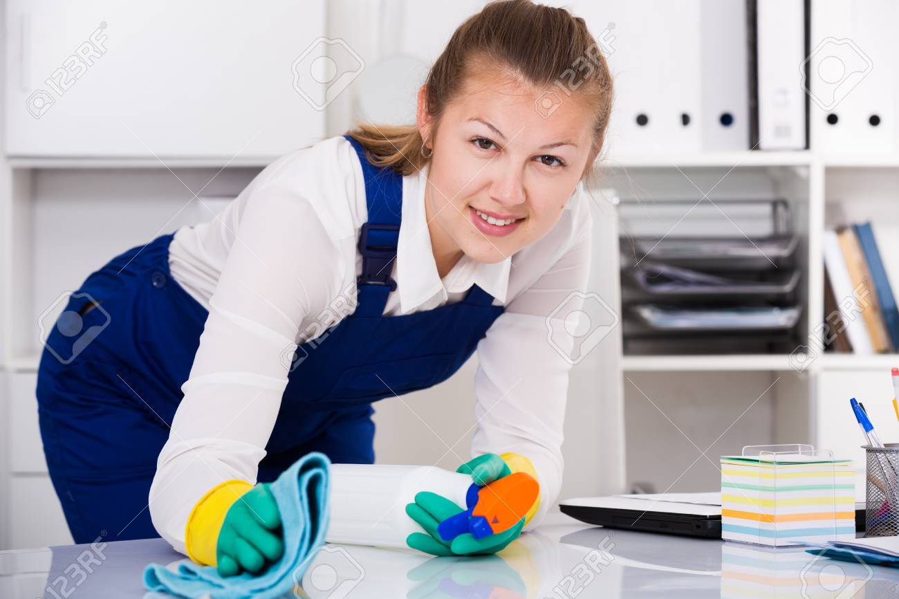 El Ama De Llaves Está Limpiando El Polvo Del Escritorio En La Oficina.  Fotos, retratos, imágenes y fotografía de archivo libres de derecho. Image  89846243