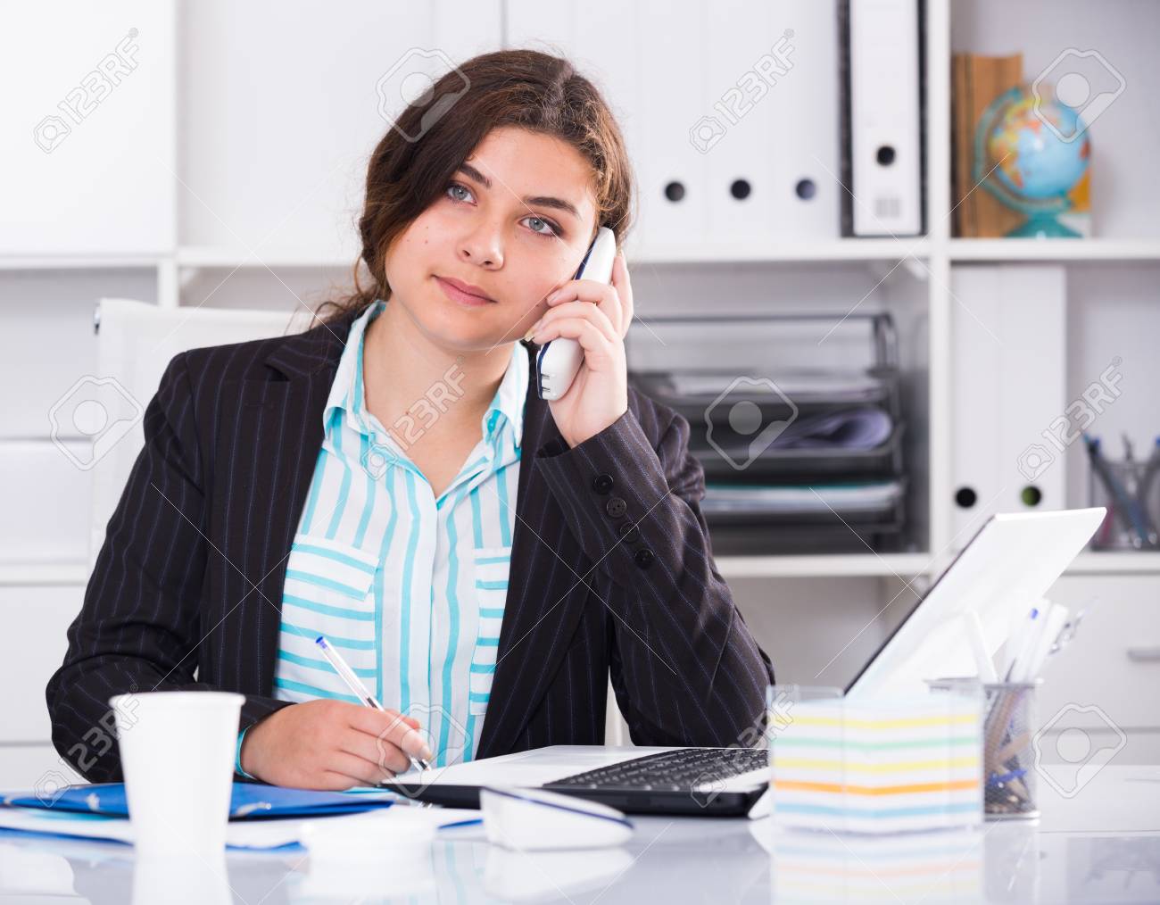 Office Worker Woman Is Working At A Computer And Talking Phone In The Office. Stock Photo, Picture And Royalty Free Image. Image 91948255.