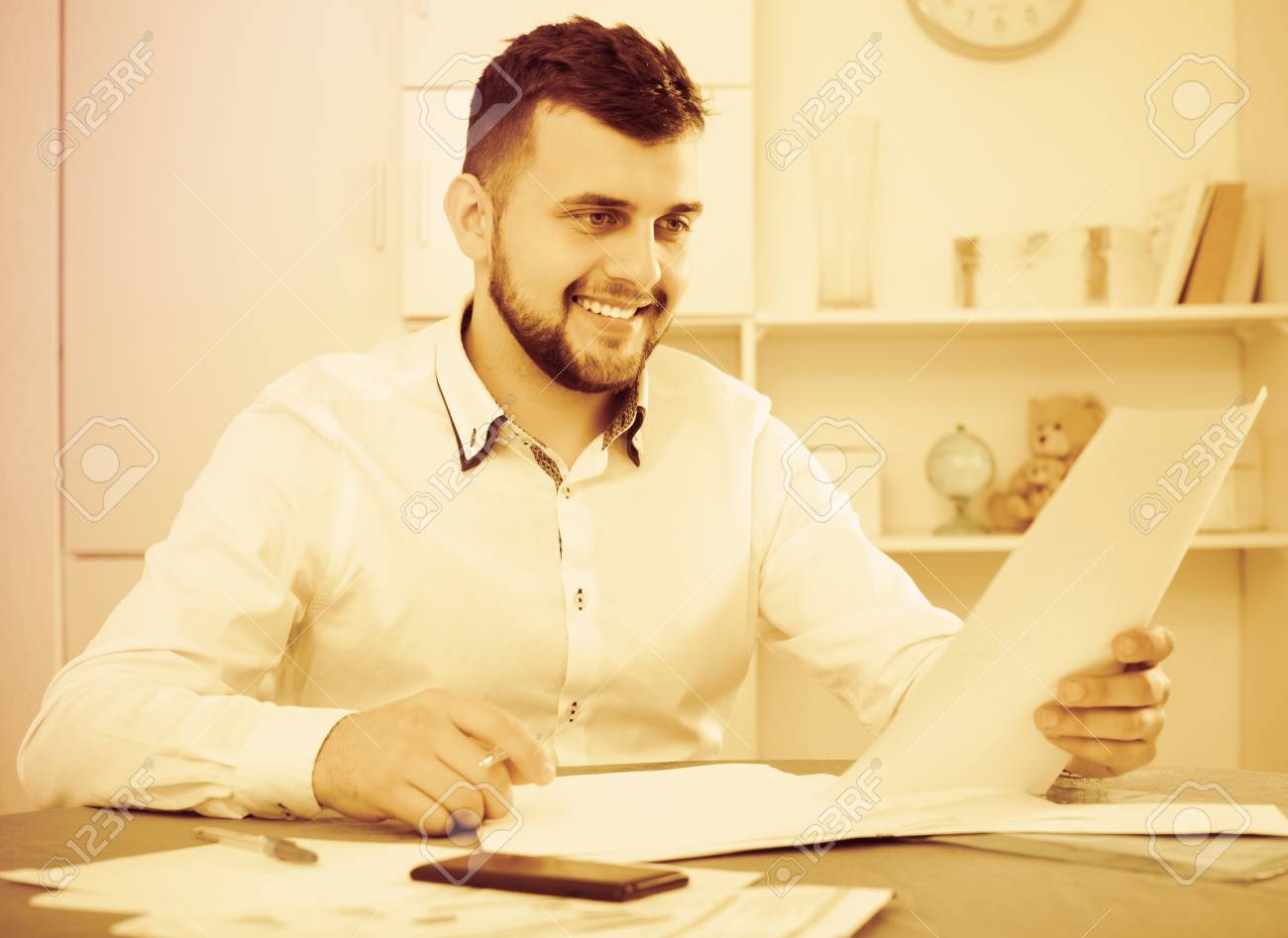 smiling male preparing agreement papers about finances at home stock