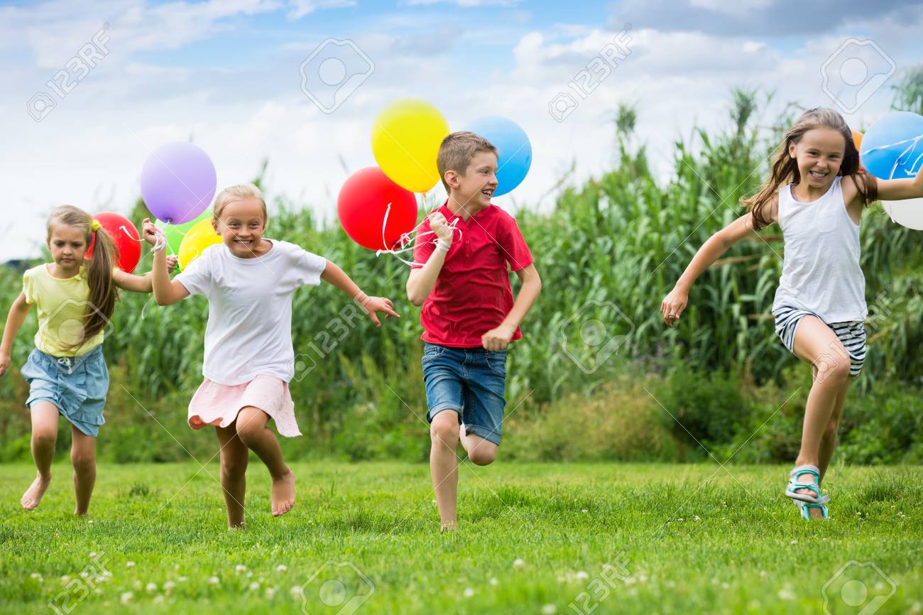 Active Kids Having Fun And Running With Multicolored Balloons At Backyard In Summer Time Stock P O Active Kids Having Fun And Running With Multicolored Balloons At Backyard In Summer Time Stock P O