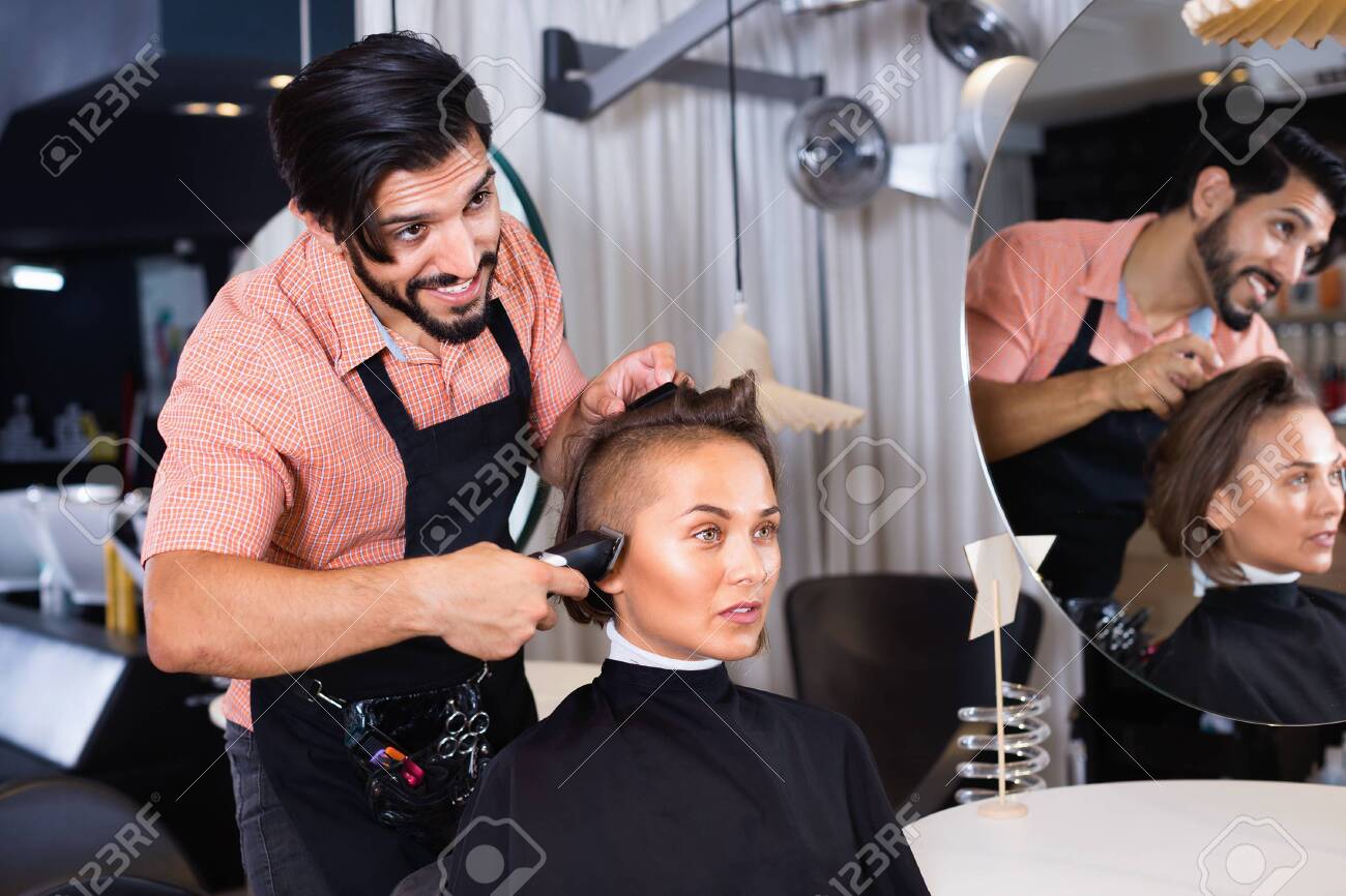 Portrait of cheerful positive man hairdresser cutting woman's hair in salon - 120935273 Portrait of cheerful positive man hairdresser cutting woman's hair in salon - 120935273