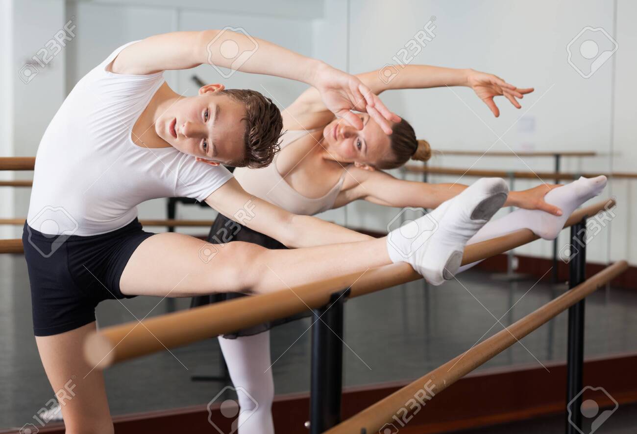 Graceful woman and young man pose in hall with ballet bar - 128645644 Graceful woman and young man pose in hall with ballet bar - 128645644