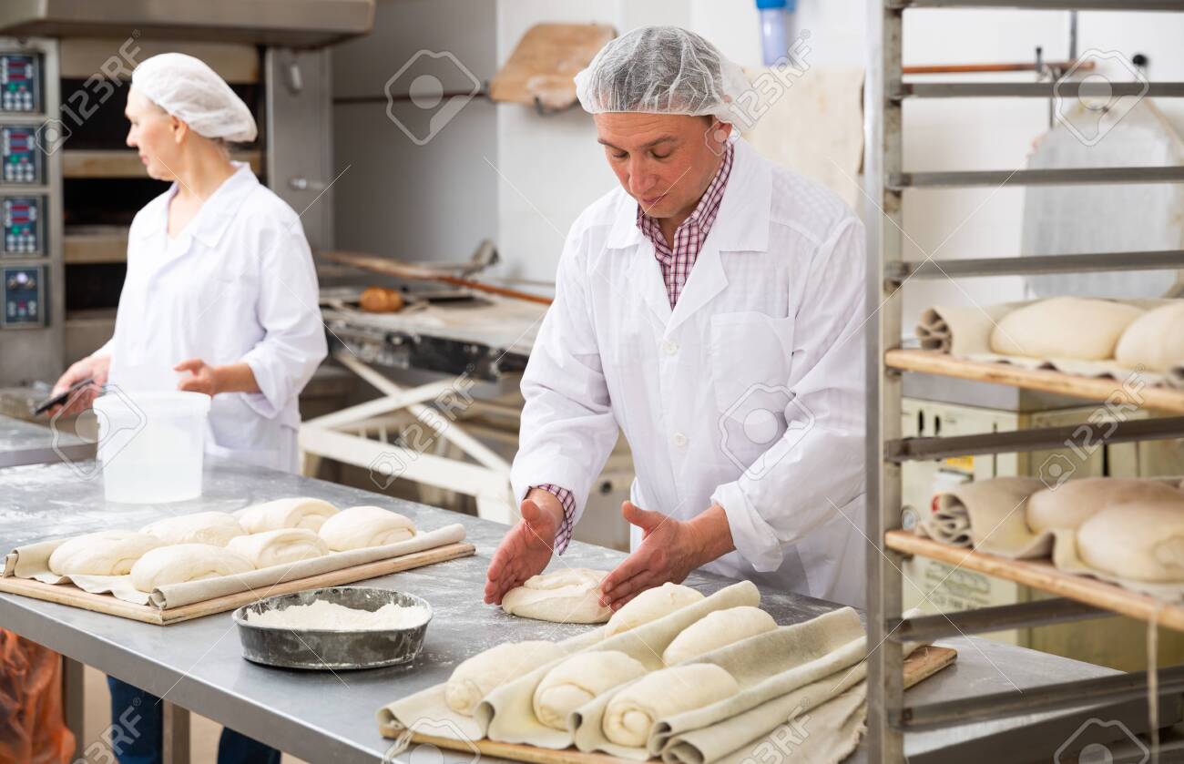 Baker forming dough for baking bread - 154475489 Baker forming dough for baking bread - 154475489