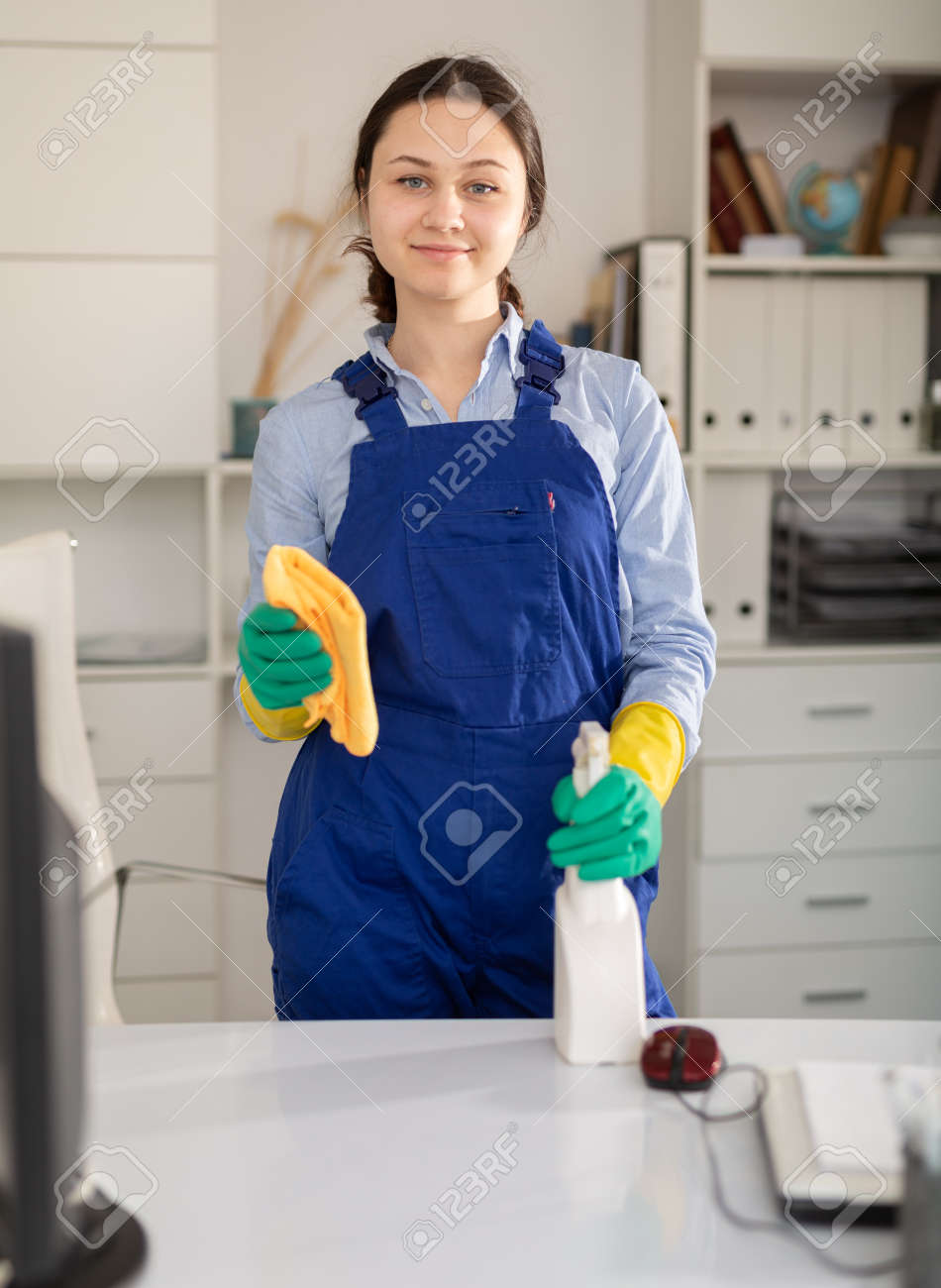 La Señora De La Limpieza En Monos Limpia El Polvo De La Mesa En La Oficina  Fotos, retratos, imágenes y fotografía de archivo libres de derecho. Image  168088371