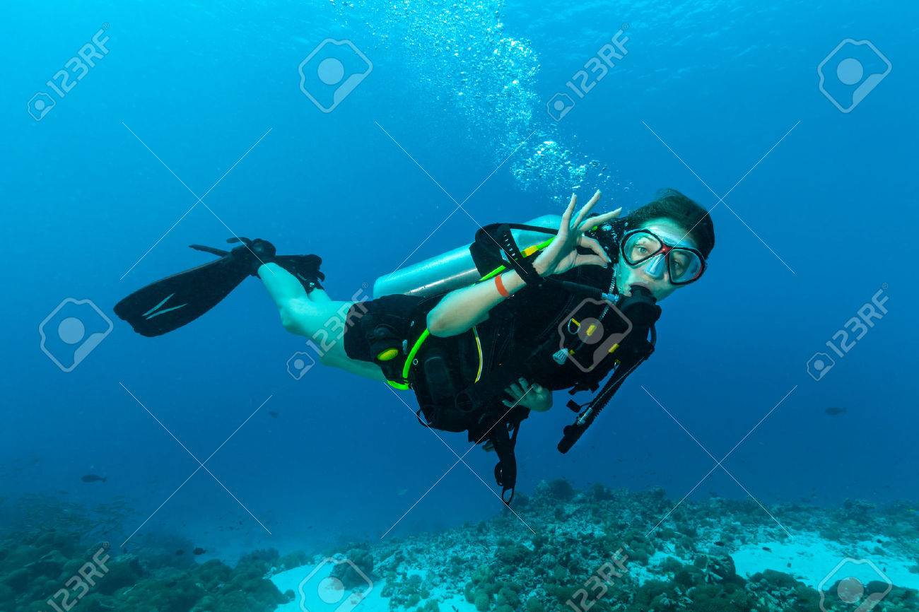 Young female scuba diver underwater showing ok signal - 52507572 Young female scuba diver underwater showing ok signal - 52507572