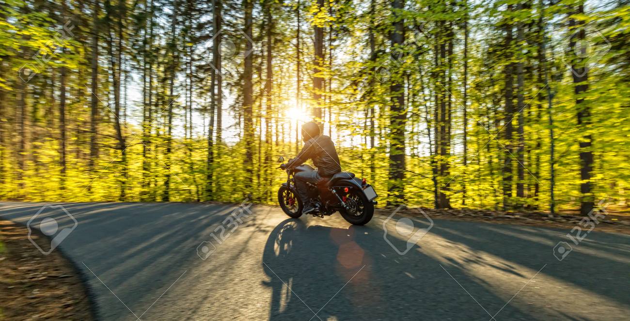 Motorcycle driver driving in forest, beautiful sunset - 70587276 Motorcycle driver driving in forest, beautiful sunset - 70587276