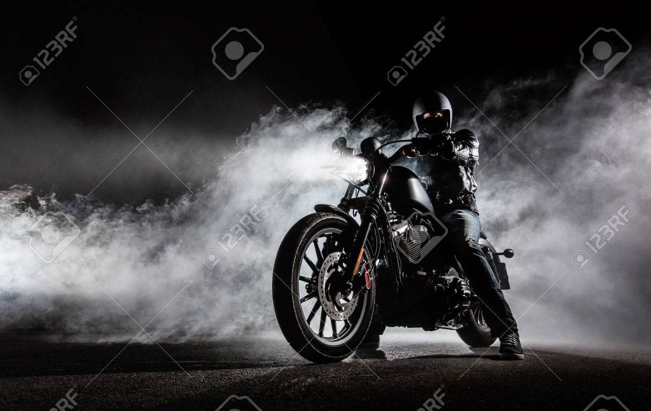 High power motorcycle chopper with man rider at night. Fog with backlights on background. - 78406752 High power motorcycle chopper with man rider at night. Fog with backlights on background. - 78406752