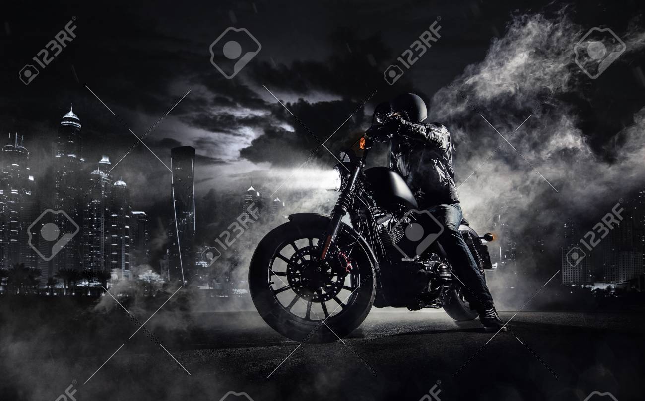 Detail of high power motorcycle chopper with man rider at night. Modern city of Dubai and fog with backlights on background. - 80901327 Detail of high power motorcycle chopper with man rider at night. Modern city of Dubai and fog with backlights on background. - 80901327