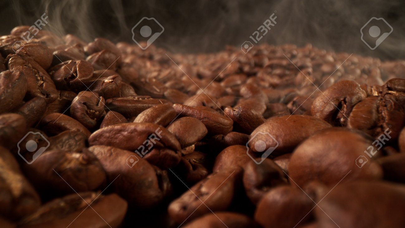 Pile of fresh roasted coffee beans with smoke around. Delicious coffee background - 168093359 Pile of fresh roasted coffee beans with smoke around. Delicious coffee background - 168093359