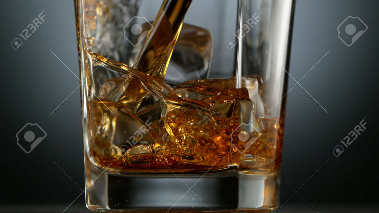 Pouring Glass of scotch whiskey and ice. Freeze motion of splashing liquid. - 170236873 Pouring Glass of scotch whiskey and ice. Freeze motion of splashing liquid. - 170236873