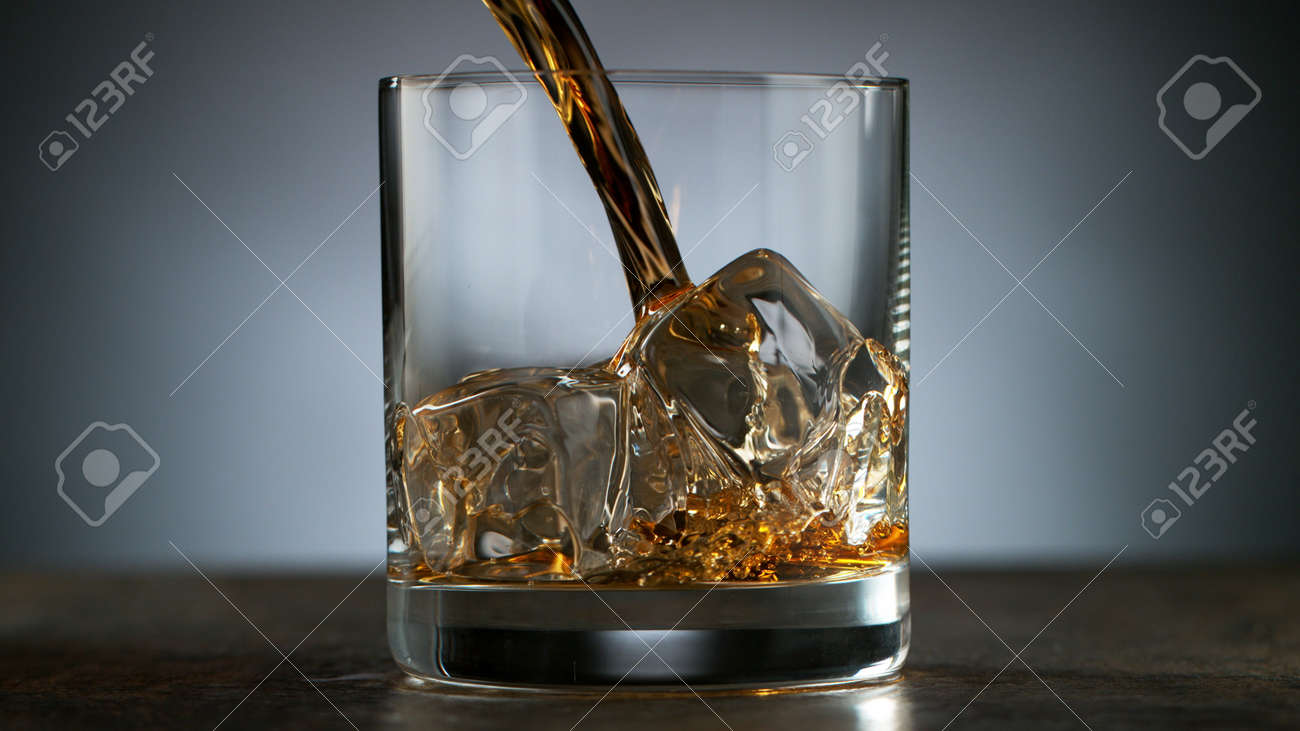 Pouring Glass of scotch whiskey and ice. Freeze motion of splashing liquid. - 170236973 Pouring Glass of scotch whiskey and ice. Freeze motion of splashing liquid. - 170236973