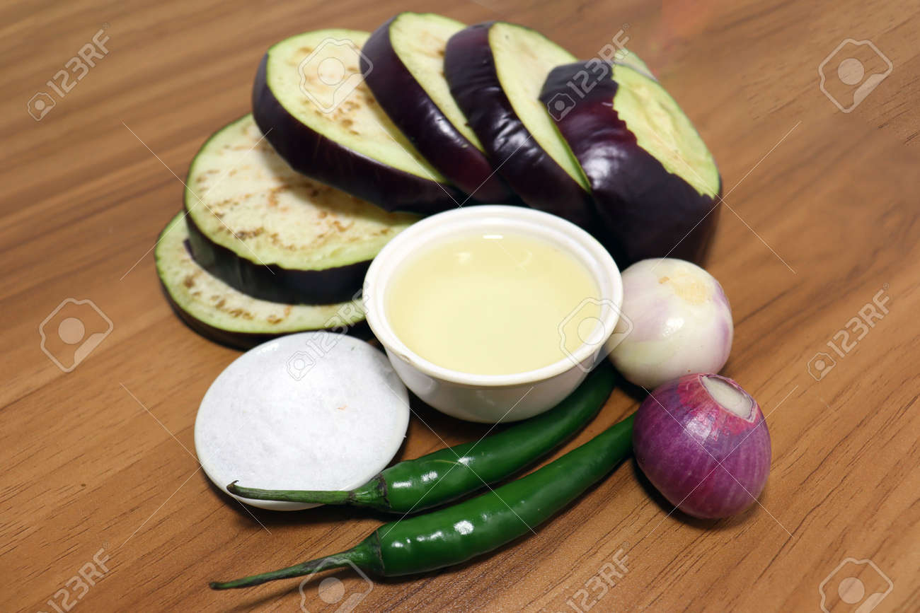 tasty and healthy violet colored Brinjal with spices on wooden table for cooking - 170868002 tasty and healthy violet colored Brinjal with spices on wooden table for cooking - 170868002