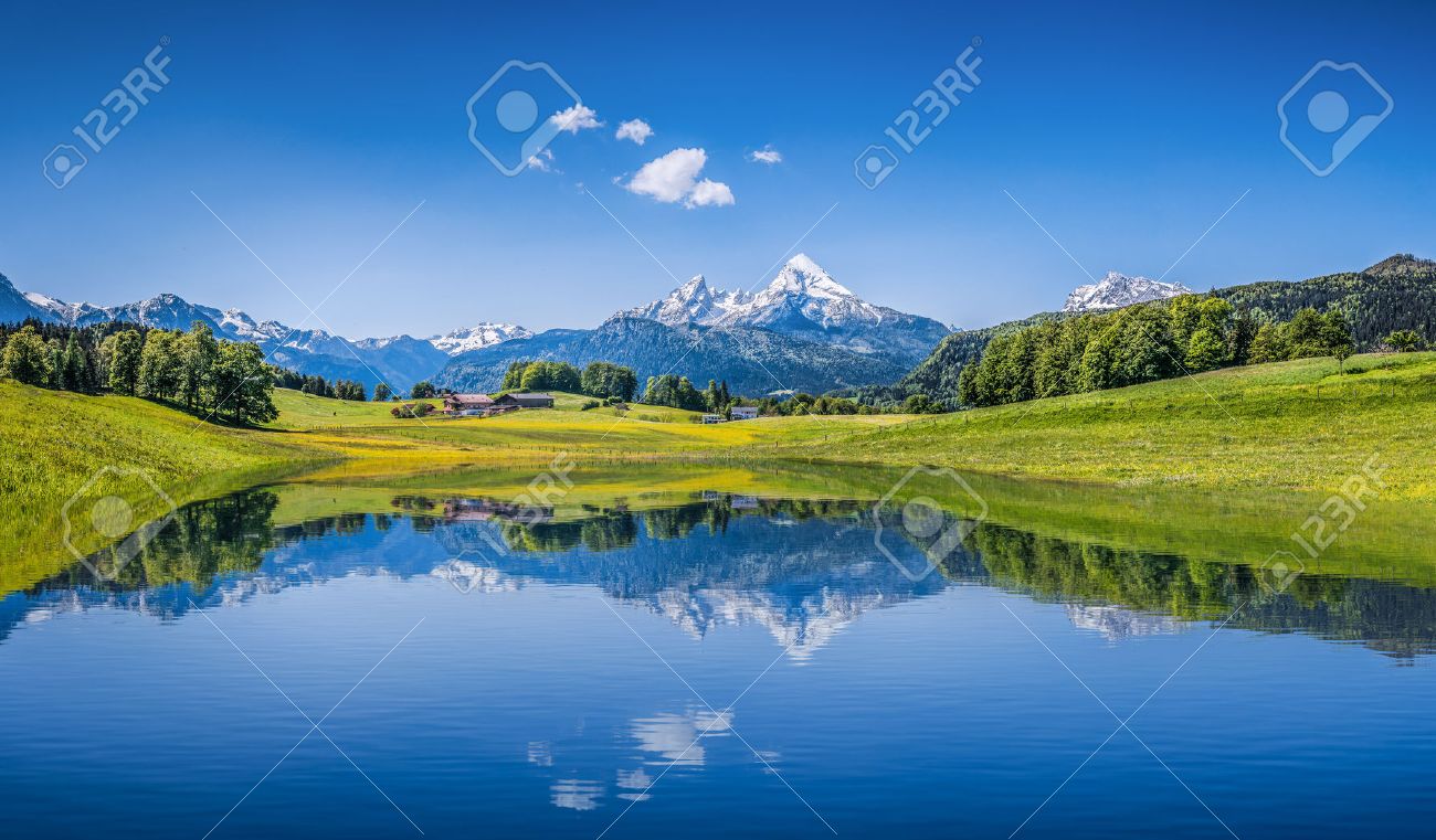 牧歌的な夏の風景とアルプスのパノラマの景色は山の湖をオフにし バック グラウンドで新鮮な緑山の牧草地 の写真素材 画像素材 Image
