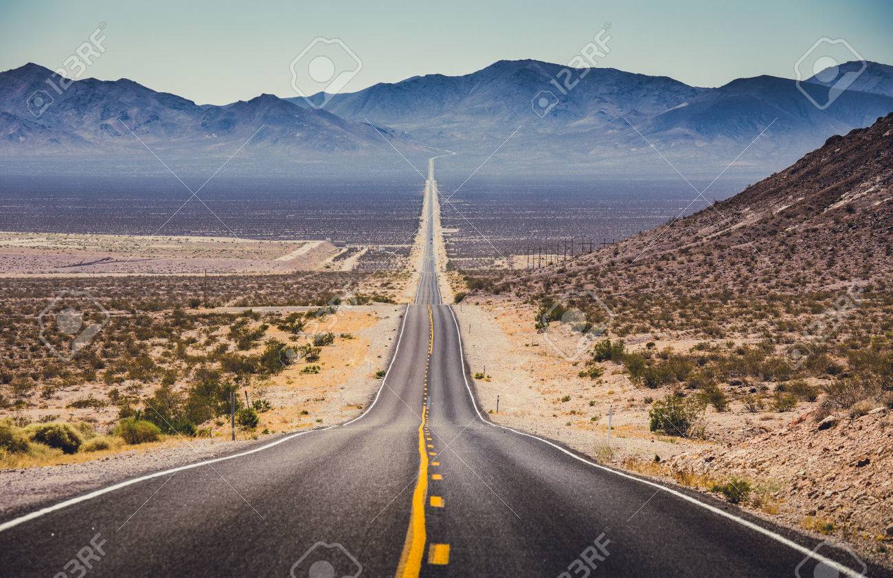 Classic panorama view of an endless straight road running through the barren scenery of the American Southwest with extreme heat haze on a beautiful hot sunny day with blue sky in summer - 80060826 Classic panorama view of an endless straight road running through the barren scenery of the American Southwest with extreme heat haze on a beautiful hot sunny day with blue sky in summer - 80060826